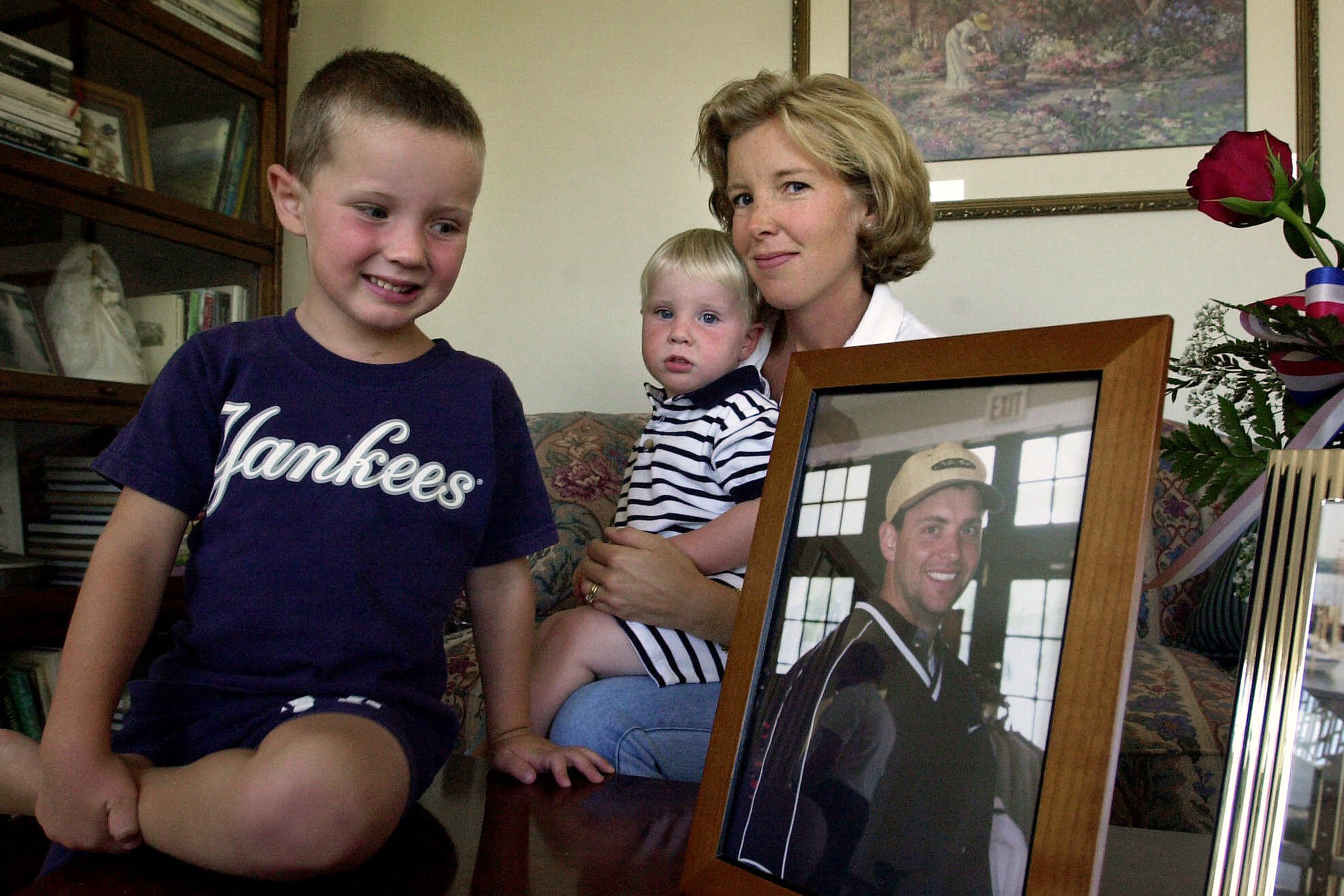 In this Sept. 16, 2001 file photo, David Beamer, his brother, Andrew, and his mother, Lisa, pose for a photo in their Cranbury, N.J. home. Lisa's husband Todd Beamer, in picture at right, was the passenger aboard the United Airlines Flight 93, who led other passengers to take action against hijackers