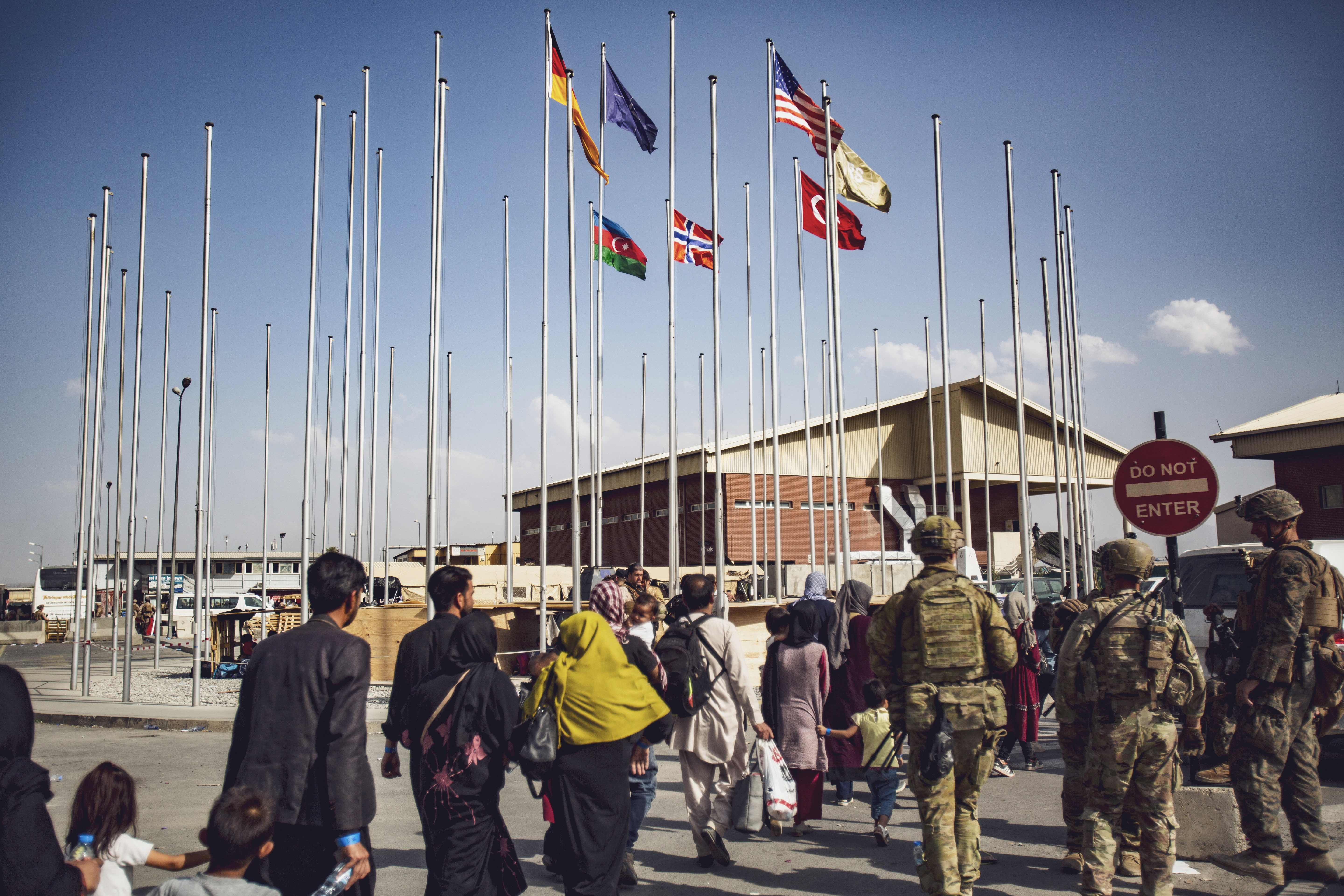 Soldiers assigned to the 82nd Airborne Division escort a group of people to the terminal at Hamid Karzai International Airport in Kabul, Afghanistan