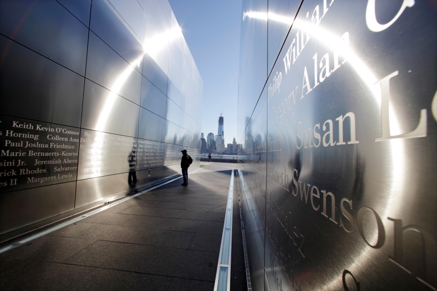 In this Tuesday, Sept. 11, 2012 file photo, a person stops to read names in New Jersey's memorial to the 749 people from the state lost during the Sept. 11, 2001 terrorist attacks on the World Trade Center, as One World Trade Center, now up to 104 floors, is seen across the Hudson River from Jersey City, N.J.