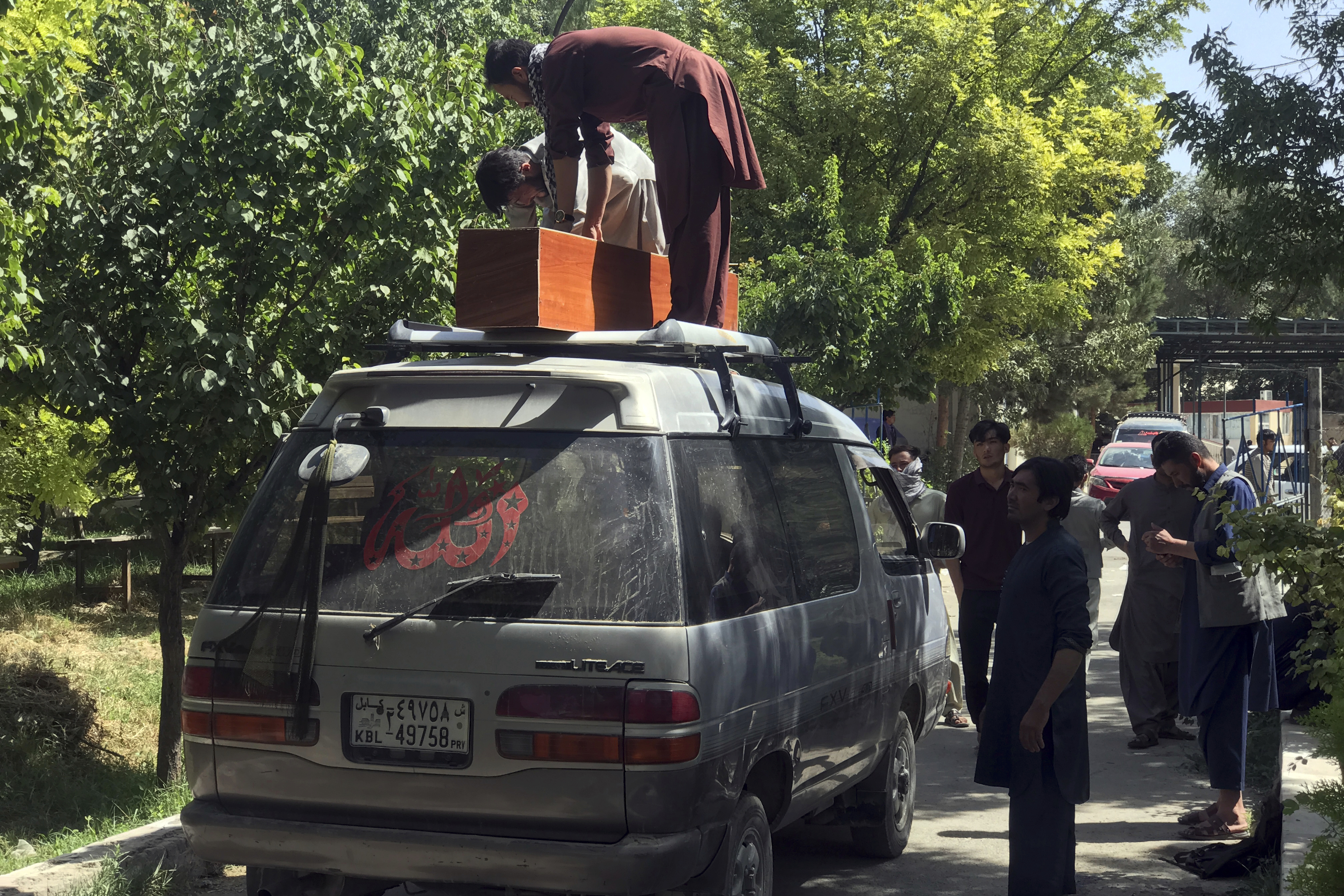 Afghans carry the dead body of an Afghan at a hospital after deadly attacks outside the airport in Kabul, Afghanistan, Friday, Aug. 27, 2021. Two suicide bombers and gunmen attacked crowds of Afghans flocking to Kabul's airport Thursday, transforming a scene of desperation into one of horror in the waning days of an airlift for those fleeing the Taliban takeover.