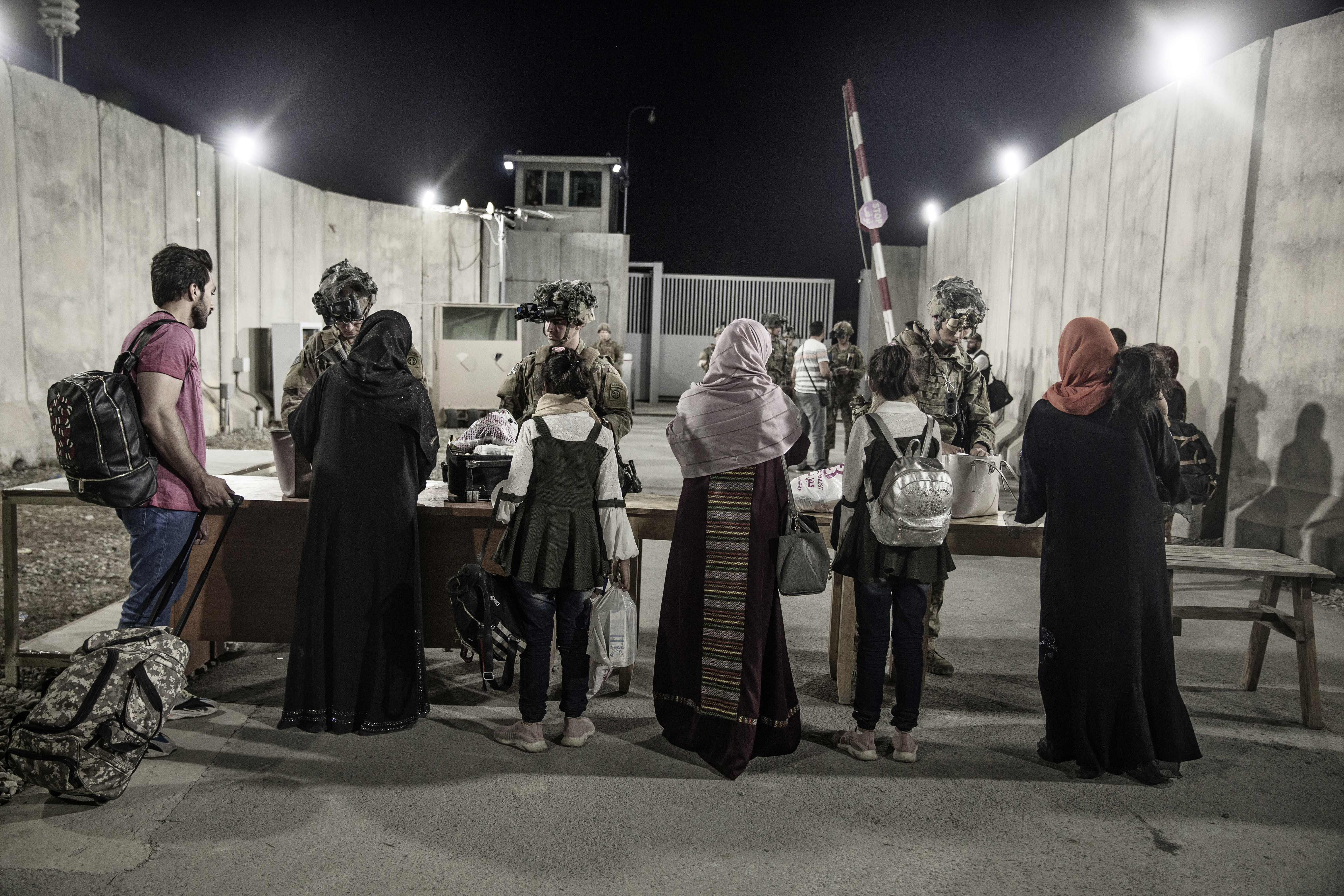 Soldiers with the 82nd Airborne Division check evacuees during an evacuation at Hamid Karzai International Airport inb Kabul, Afghanistan,