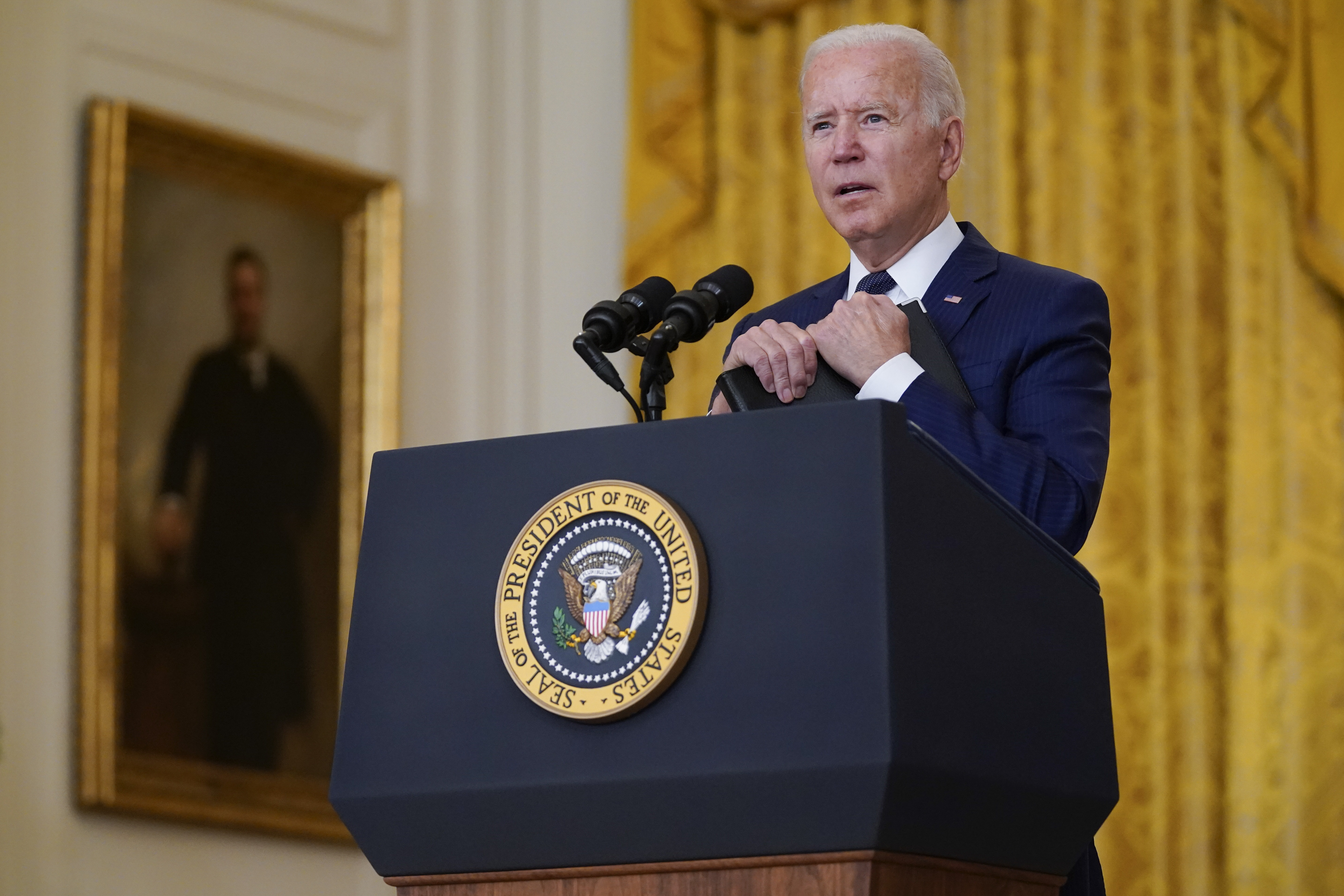 President Joe Biden answers questions from members of the media about the bombings at the Kabul airport that killed at least 12 U.S. service members, from the East Room of the White House in Washington.