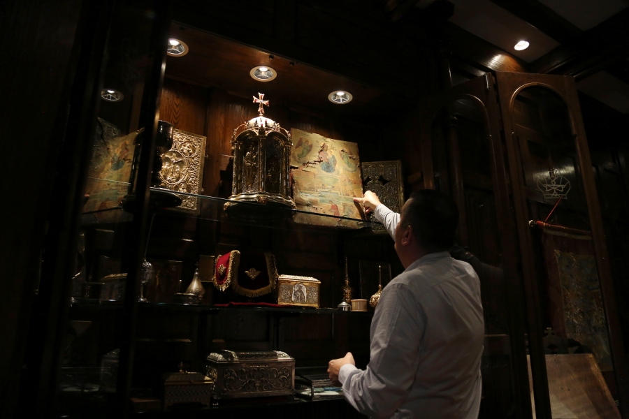 Andrew Veniopoulos reaches for an icon that was recovered from the original St. Nicholas Greek Orthodox Church, destroyed in the Sept. 11, 2001 attacks, on Wednesday, Aug. 18, 2021, at the Greek Orthodox Archdiocese of America in New York.