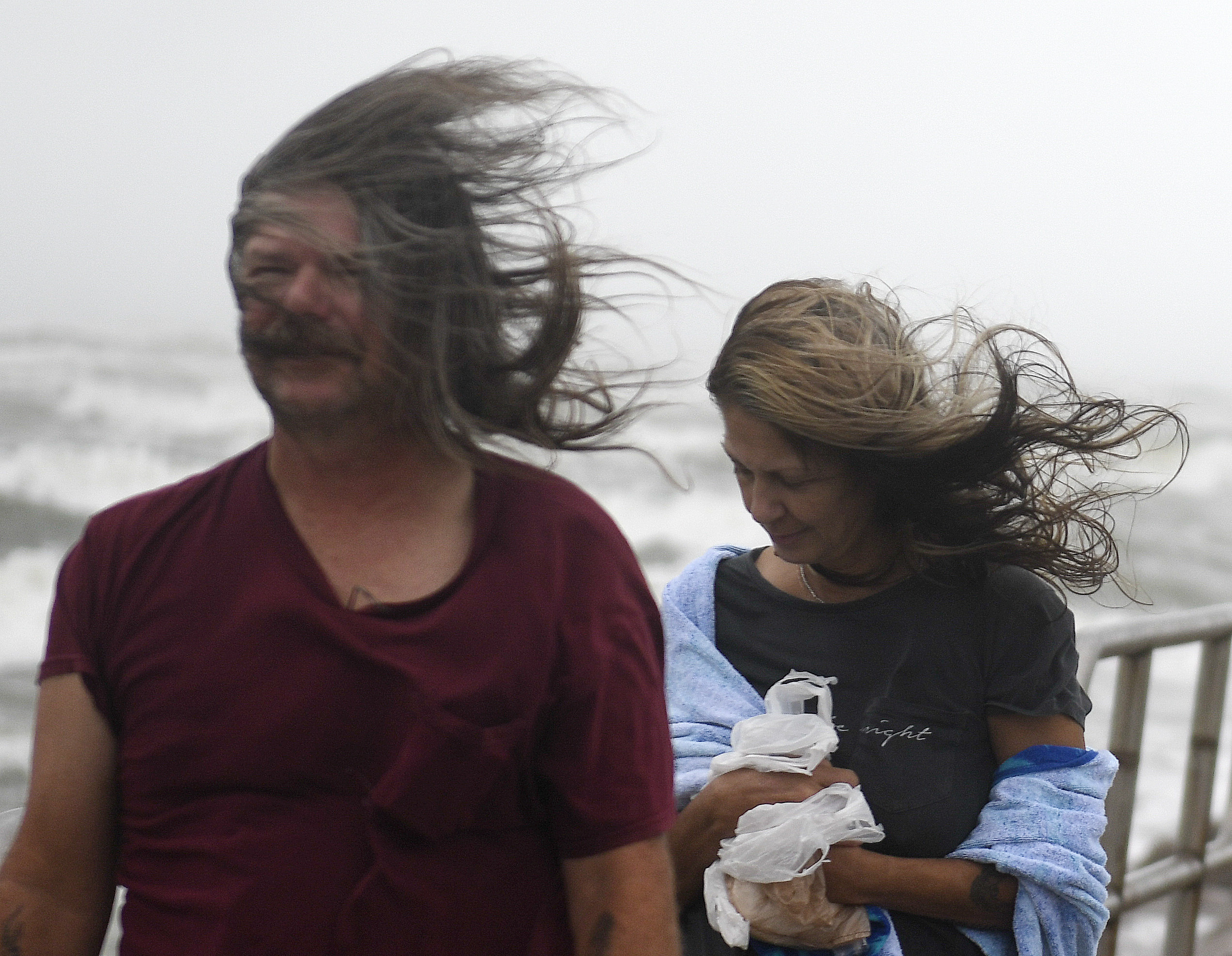 People's hair blows in the wind ahead of Tropical Storm Nicholas