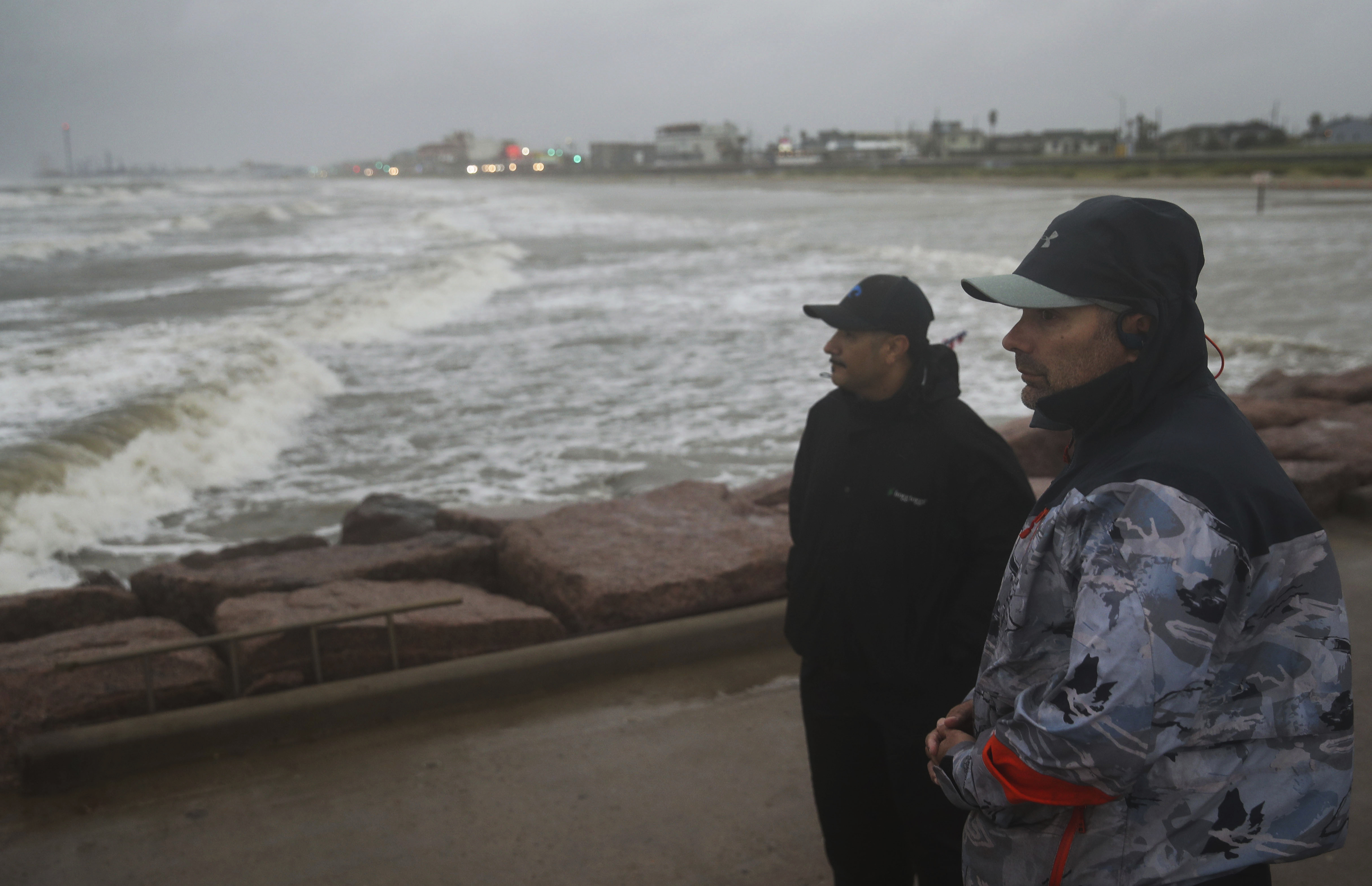 Jaime Ybarra, right, and his friend Frank Rivera watch their lines as they fish as Tropical Storm Nicholas moves toward Texas