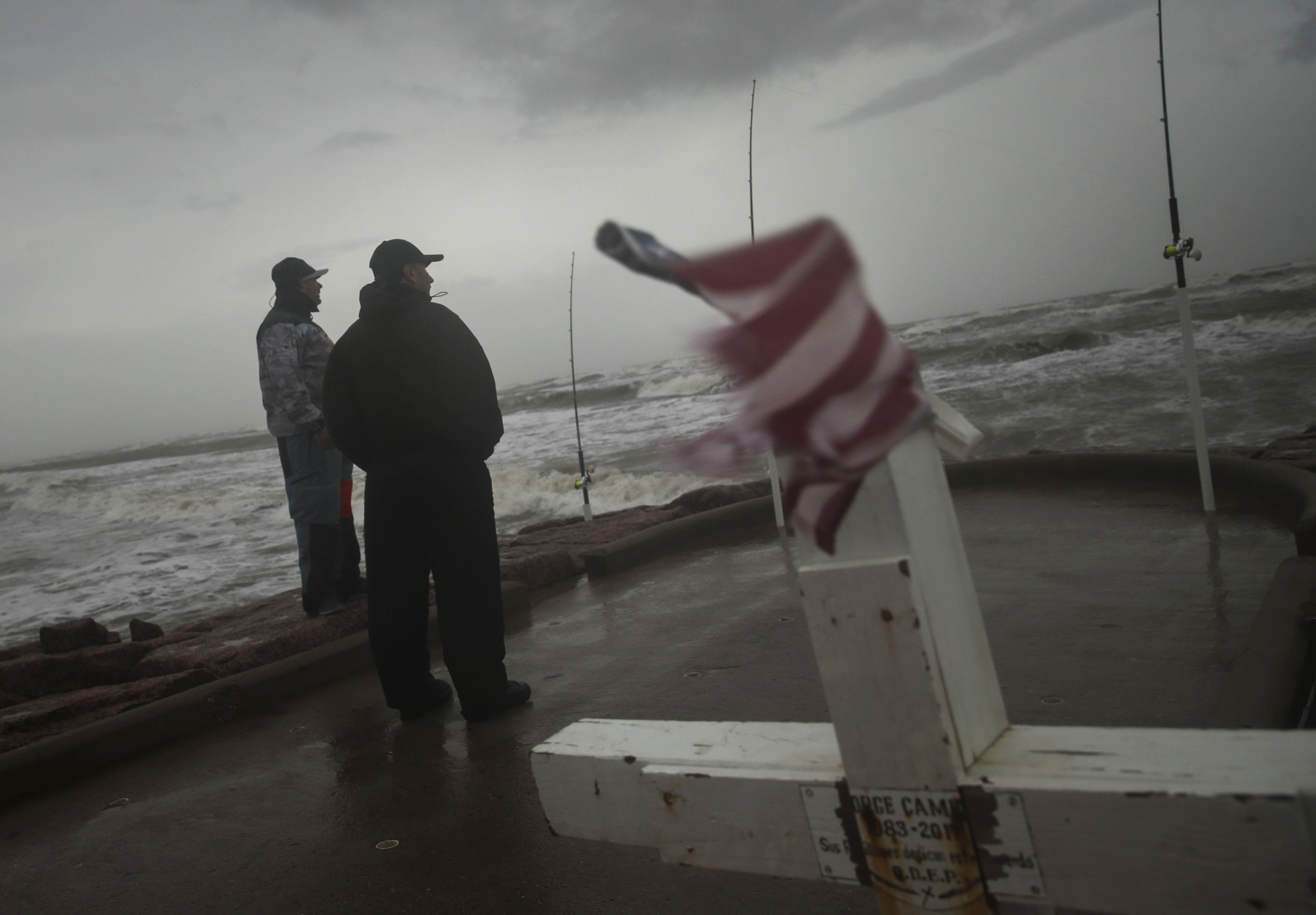 Frank Rivera, right, and his friend Jaime Ybarra watch the wind and waves as Tropical Storm Nicholas heads toward the Texas