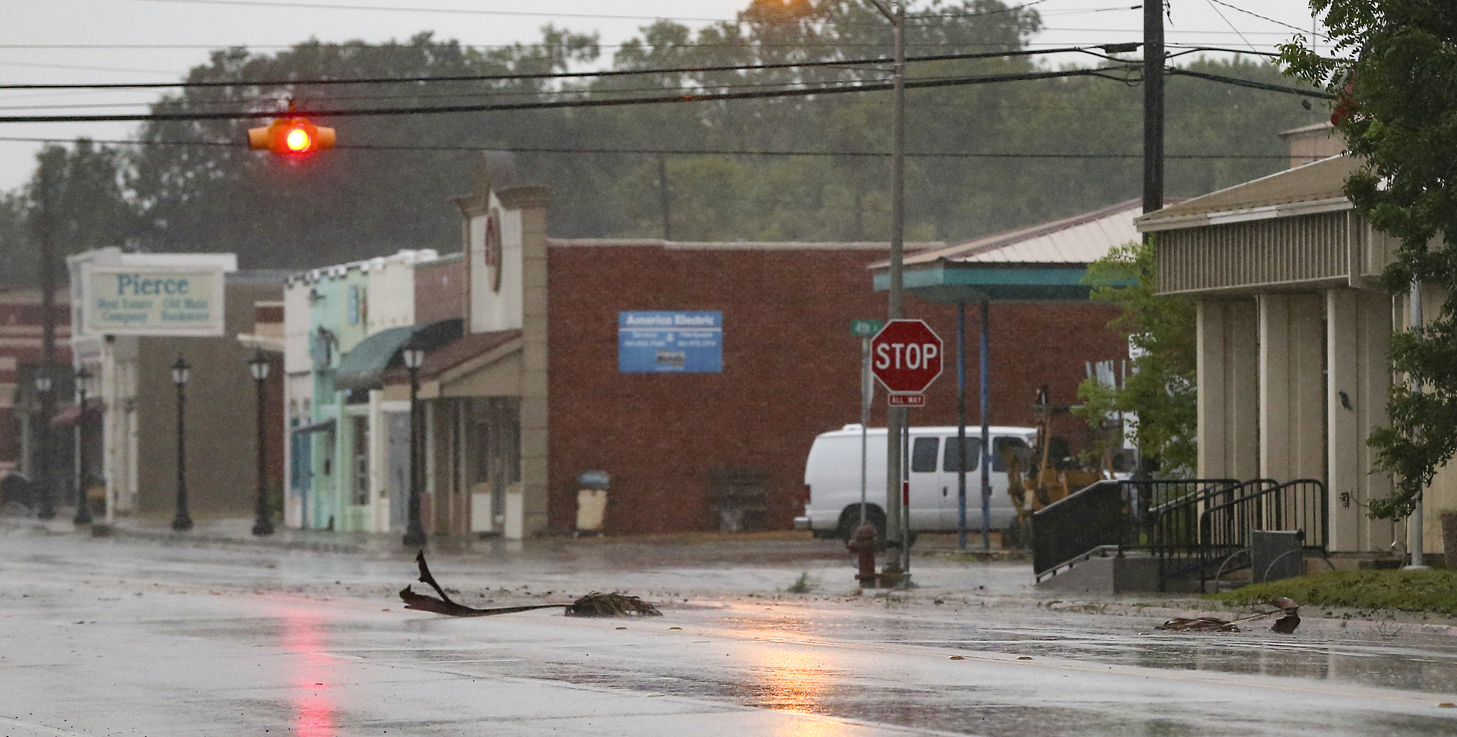 Debris from palm trees blow down the street as winds pick up as Tropical Storm Nicholas approaches on Monday