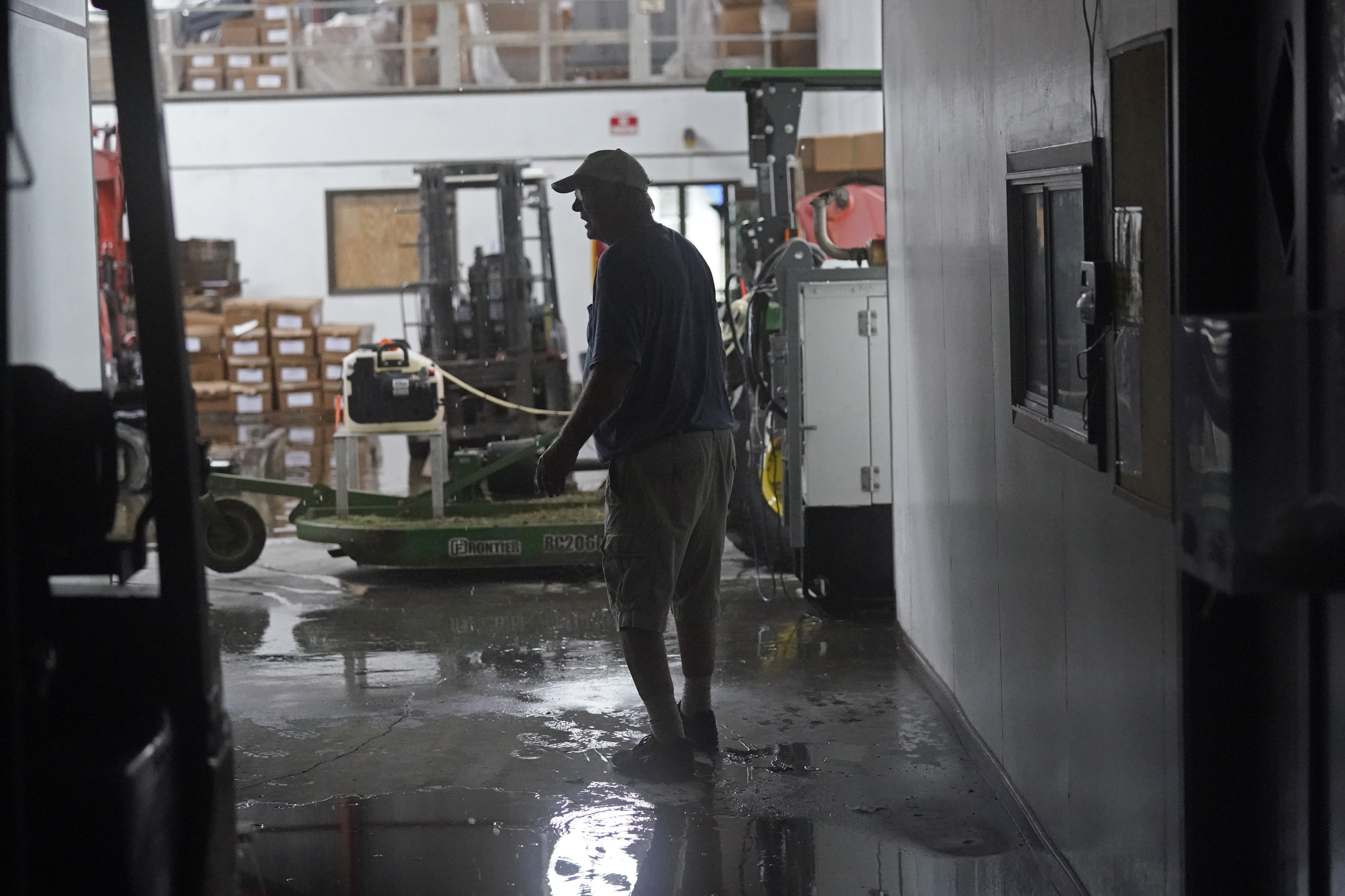 Steven Voisin walks through his family's heavily damaged oyster processing plant, as rain from Tropical Storm Nicholas, currently in the Gulf of Mexico, comes down through a destroyed roof