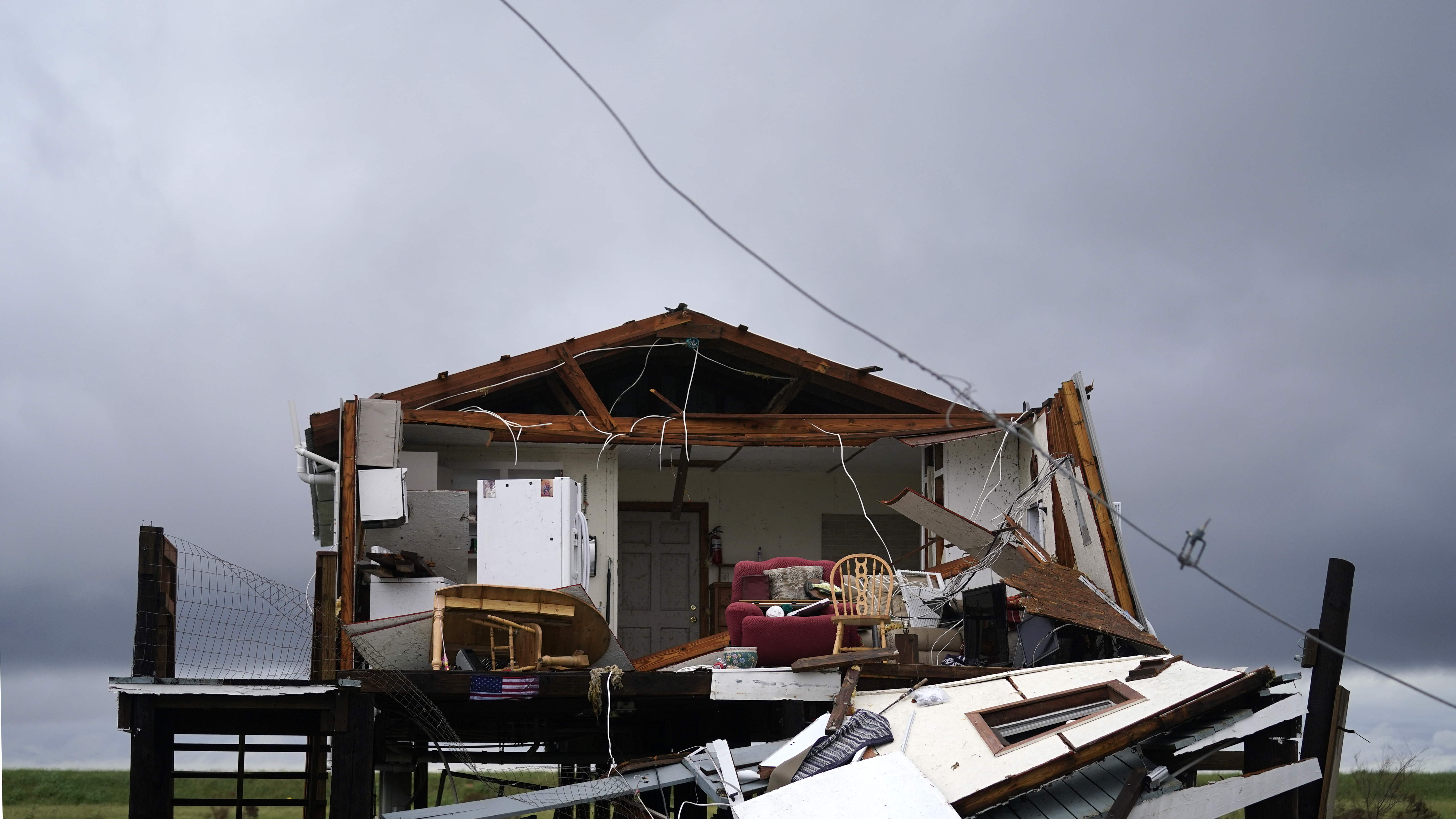 Storm clouds from Tropical Storm Nicholas are seen behind a home that was destroyed by Hurricane Ida,