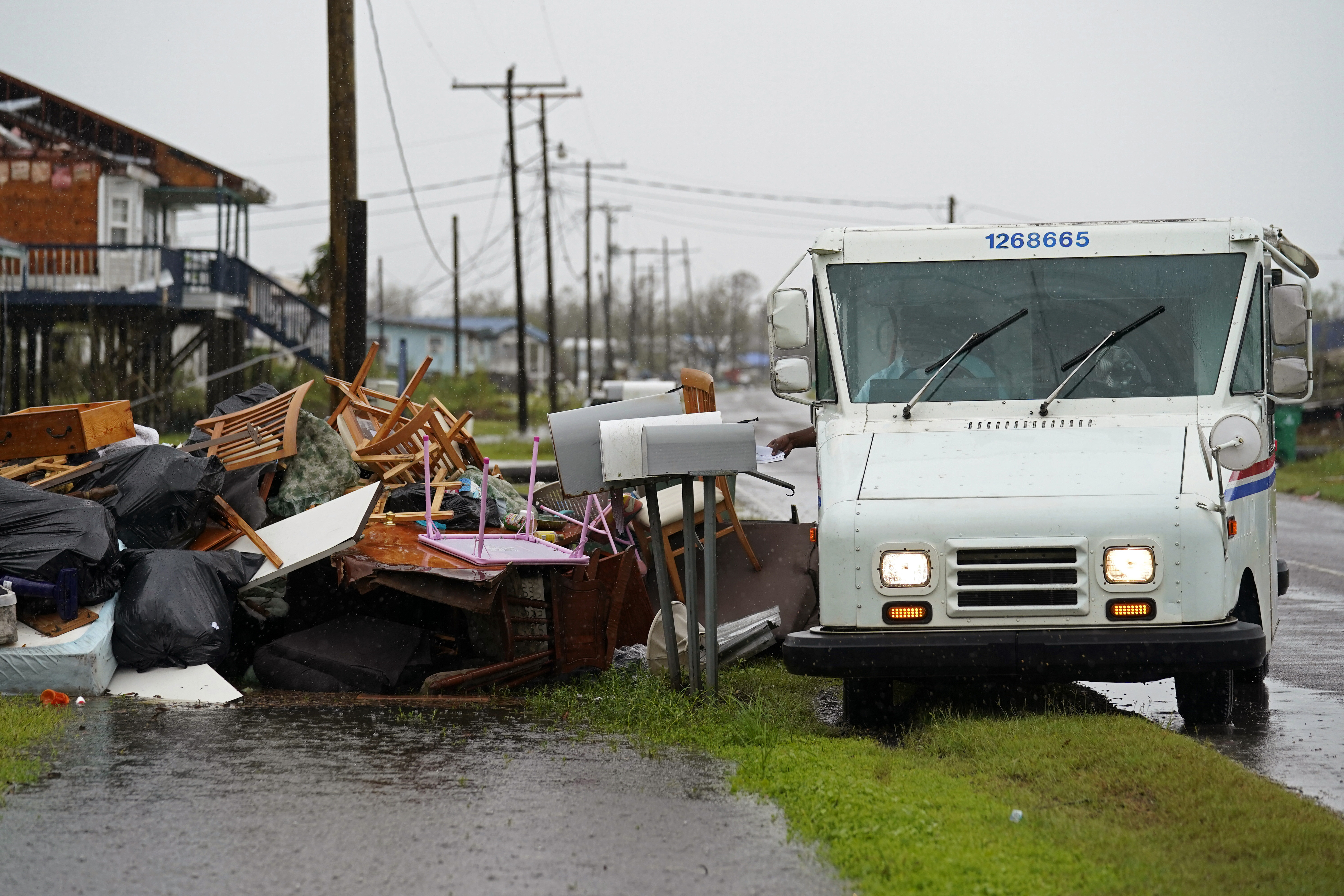 Derrick Campbell, postmaster for Montegut, La., delivers mail amidst destruction from Hurricane Ida, in Pointe-aux-Chenes, La.