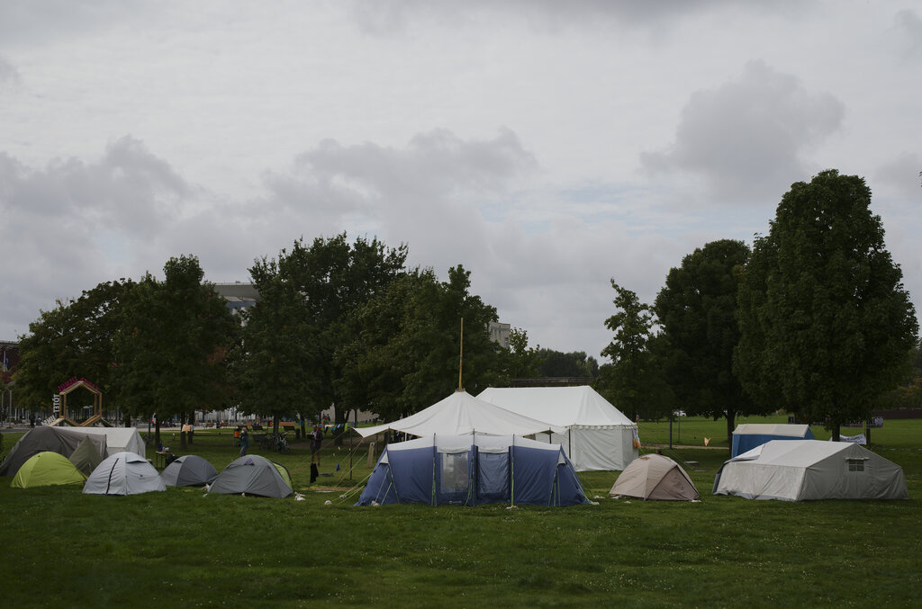 A small camp of climate activists is set up near the chancellary, background behind the trees, in Berlin, Wednesday, Sept. 22, 2021. In the camp climate activists on a hunger strike and hope to pressure candidates for chancellor of Germany into meeting them for a debate about the climate crisis ahead Sunday's general election. For the first time in Germany's history, climate change is a central issue of an election campaign, overwhelmingly so for the young generation.