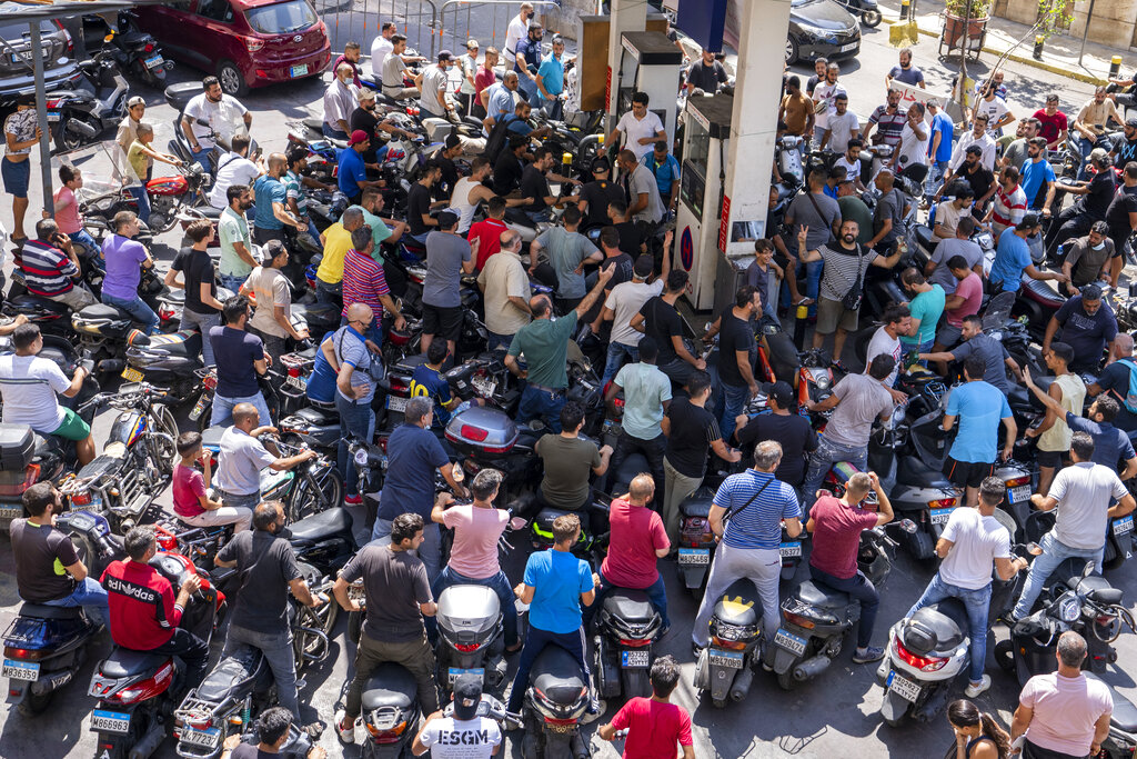 In this Aug. 31, 2021, file photo, motorcycle drivers wait to get fuel at a gas station in Beirut, Lebanon. Countries like Lebanon, Syria, Iraq, Lebanon and Yemen are all teetering on the brink of humanitarian catastrophe with an economic implosion that threatens to throw the region into even deeper turmoil.