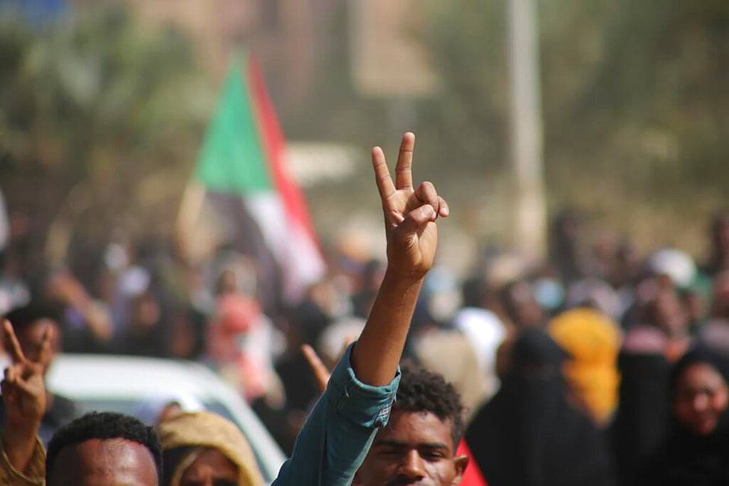 Pro-democracy protesters flash the victory sign as they take to the streets to condemn a takeover by military officials, in Khartoum, Sudan, Monday Oct. 25, 2021