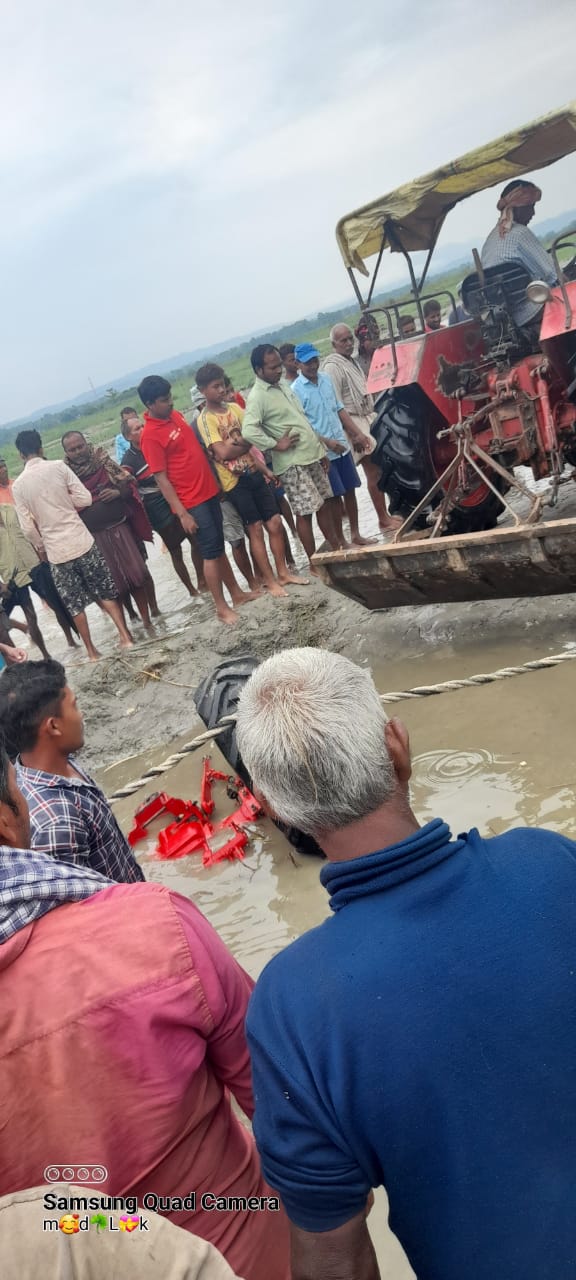 नदी से ट्रैक्टर निकालते ग्रामीण