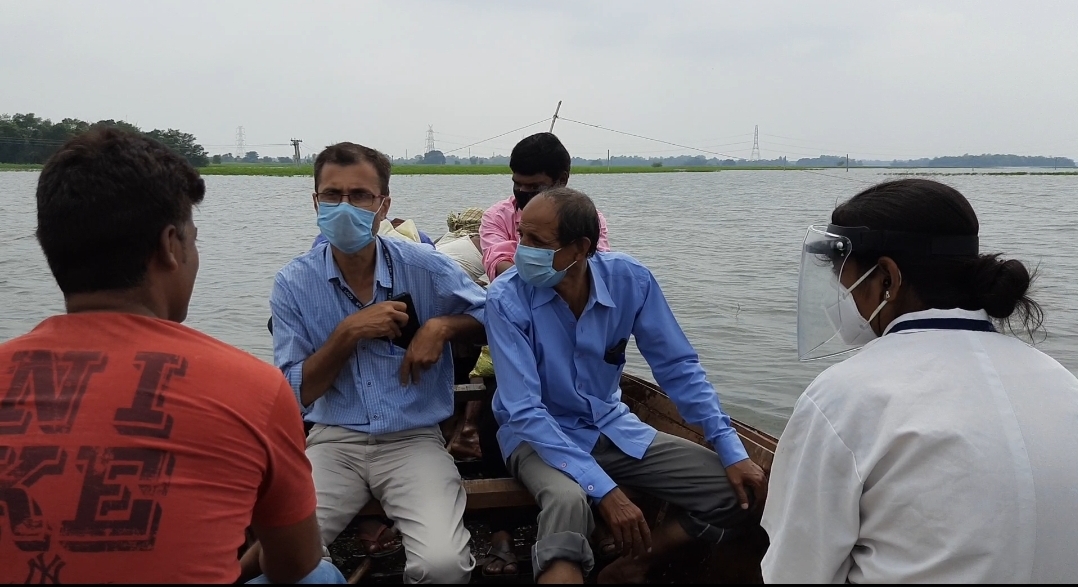 नाव से बाढ़ प्रभावित इलाके में मेडिकल कैंप लगाने जा रहे कर्मी