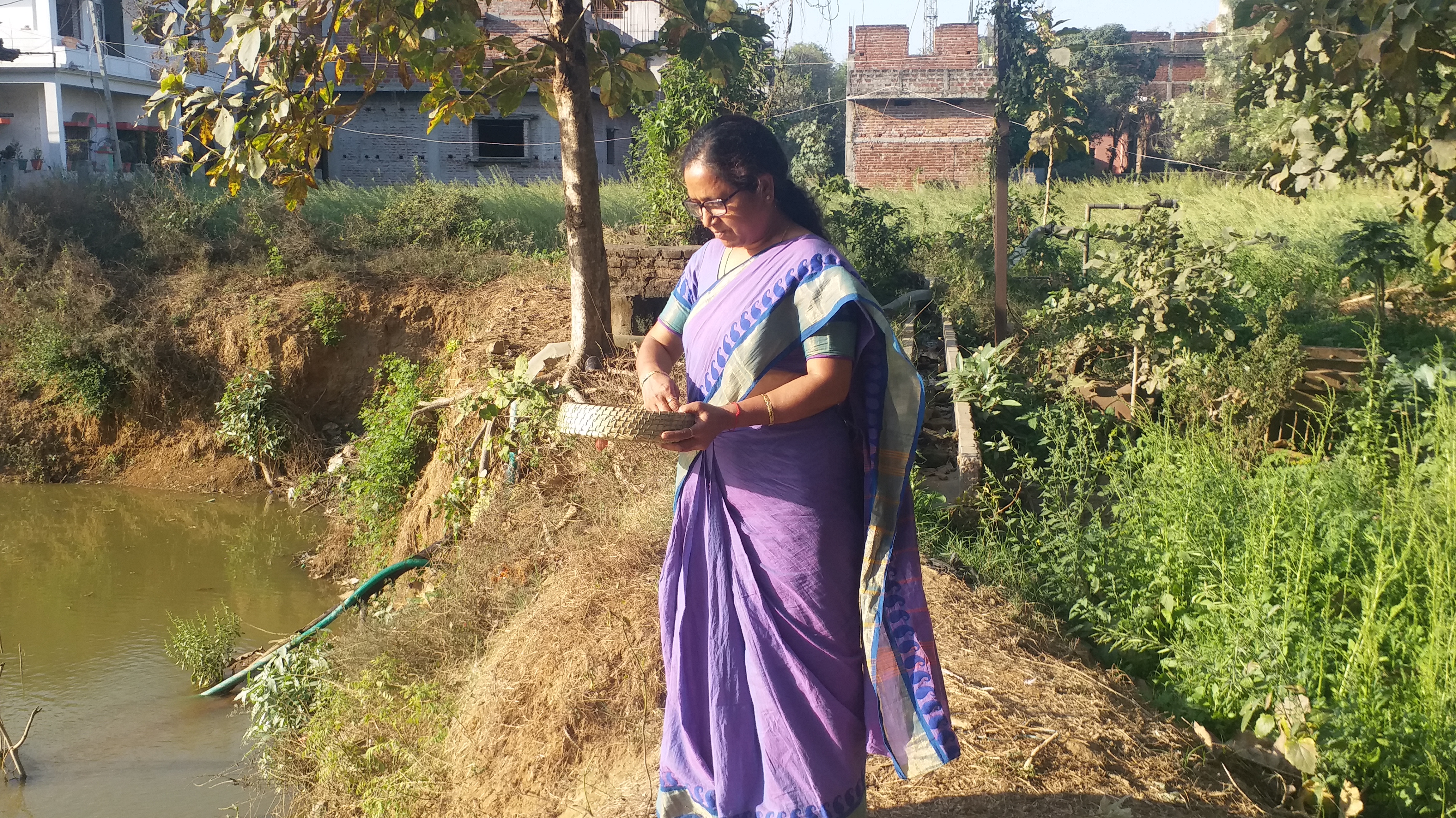 मछली को दाना खिलाती हुई महिला.