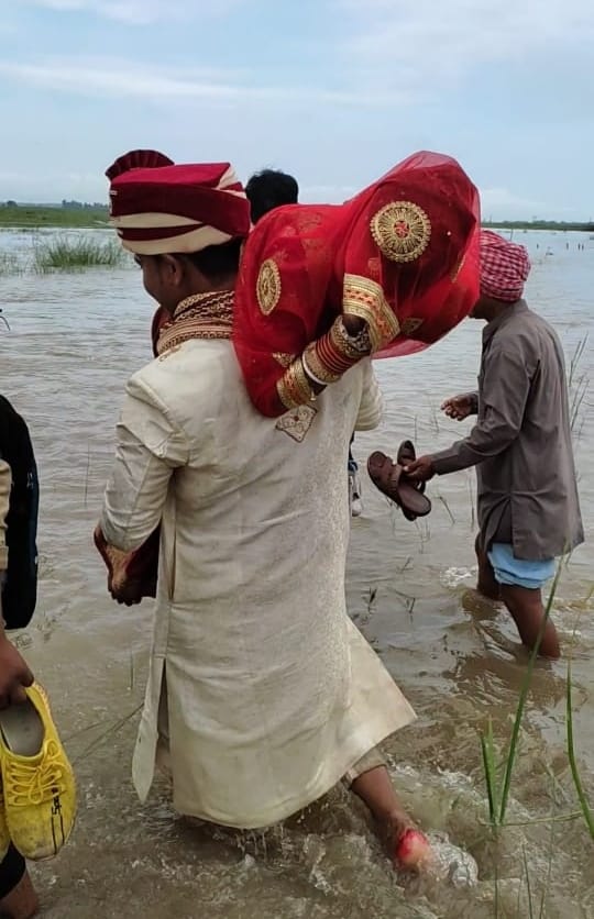 दुल्हन को कंधे पर बिठाकर सैलाब पार कराता दूल्हा