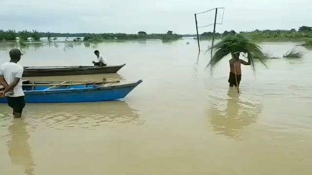 बाढ़ के पानी में खड़े लोग