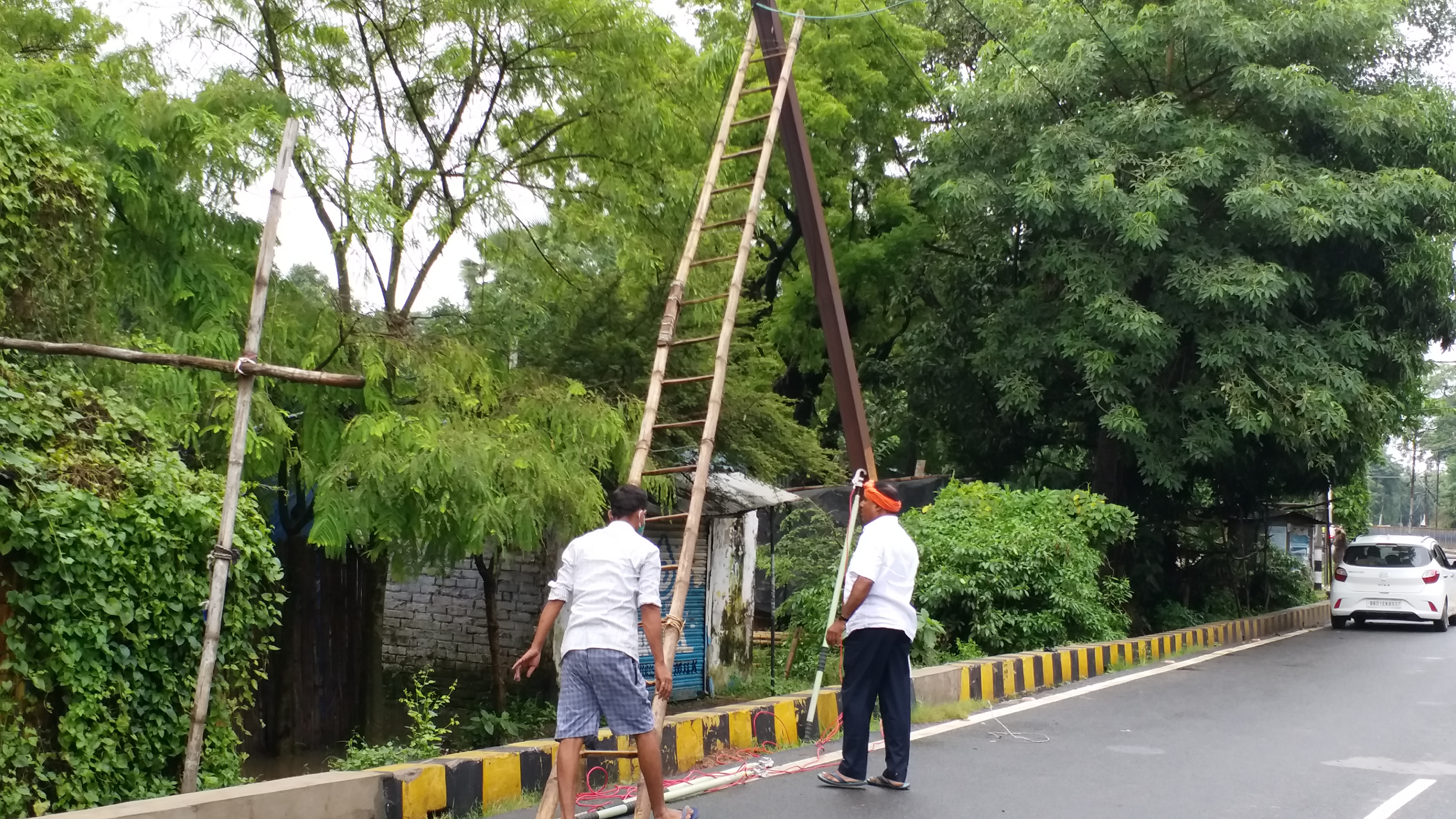 बिजली पोल को ठीक कर रहे विभाग के कर्मी