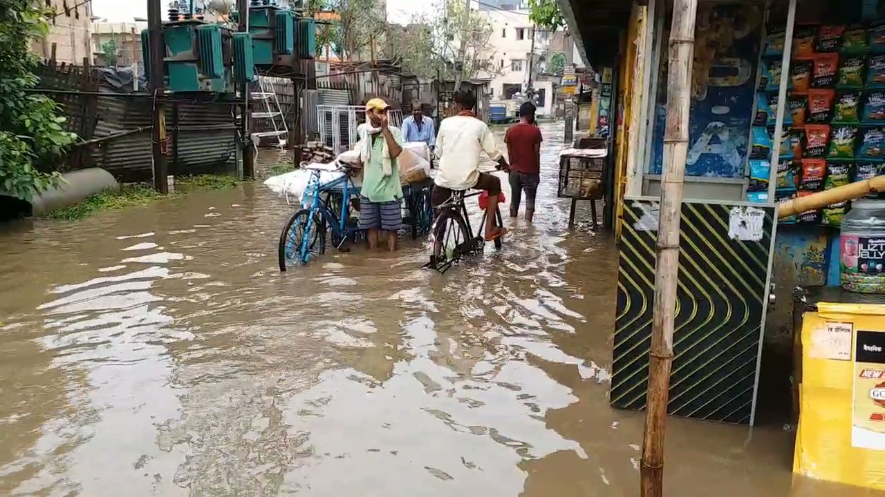 बारिश के पानी में आते-जाते लोग