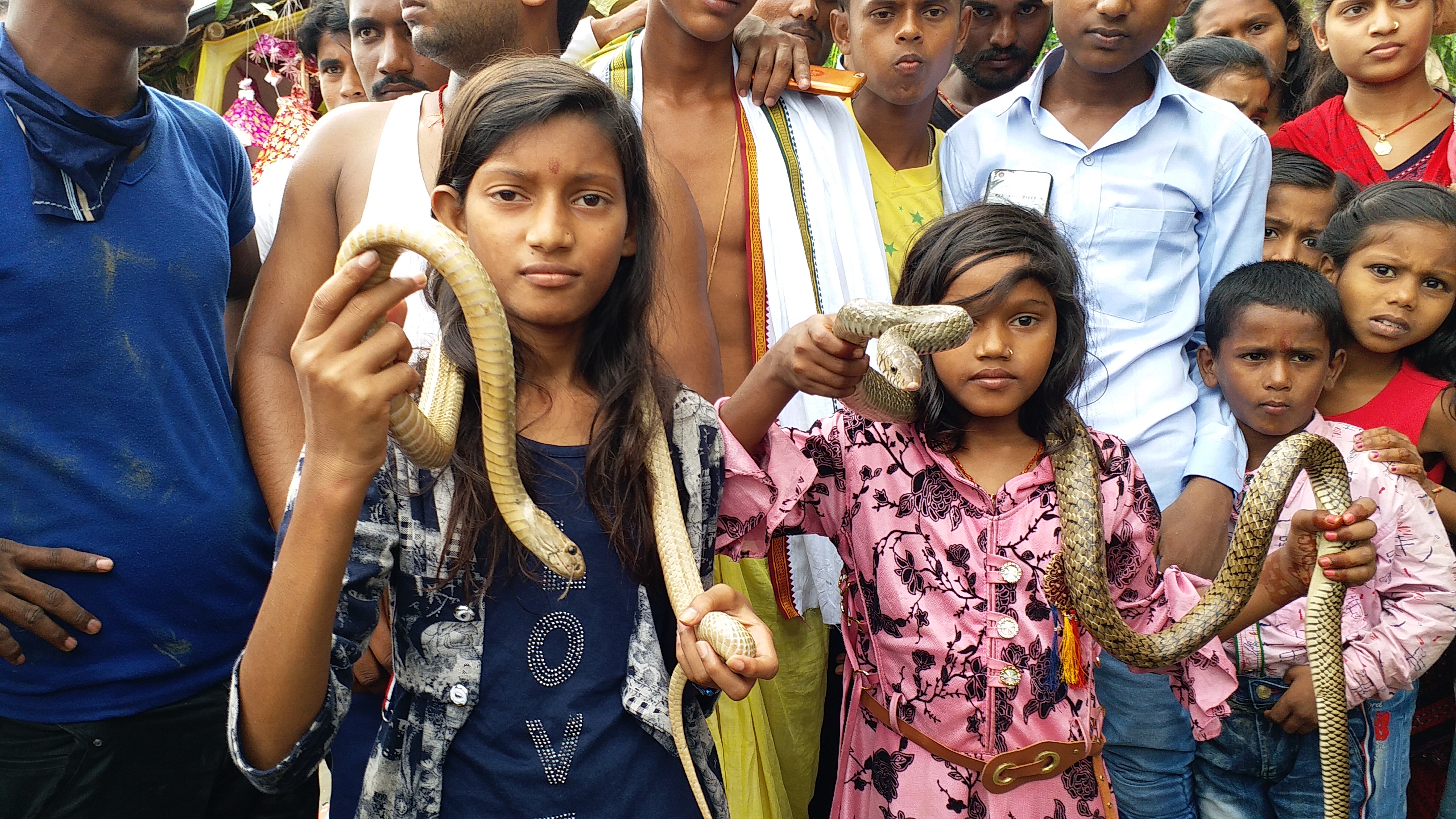 सांपों से खेलती बच्चियां