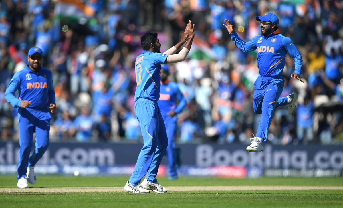 Jasprit Bumrah celebrates with Kedar Jadhav after taking a wicket.