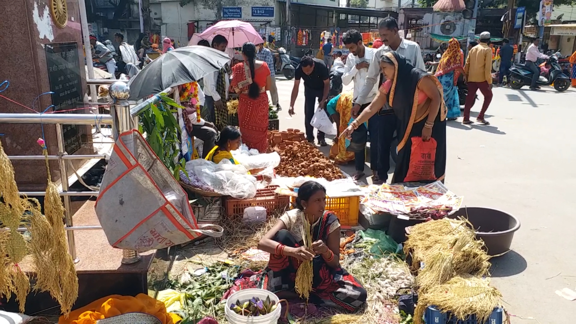 धान की झालर और घास के झाड़ू बेचती महिला दुकानदार