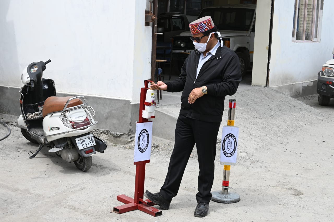 Govind Singh Thakur sanitizing hands with hands free sanitizer