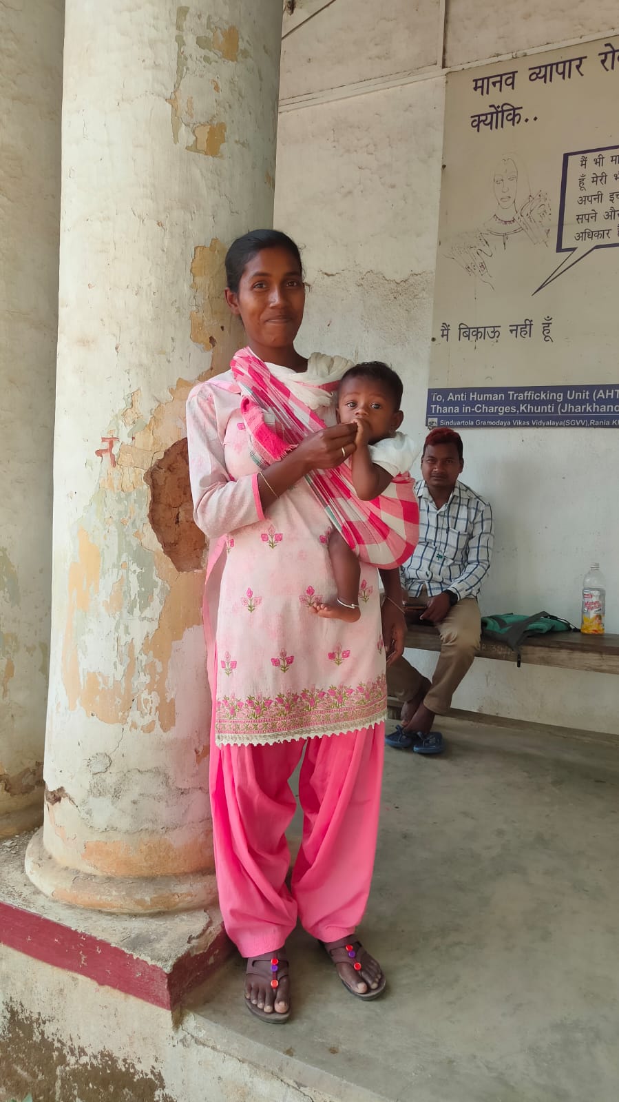 Lady constable Mukti Hissa Purti doing duty with child in her lap in Khunti police station