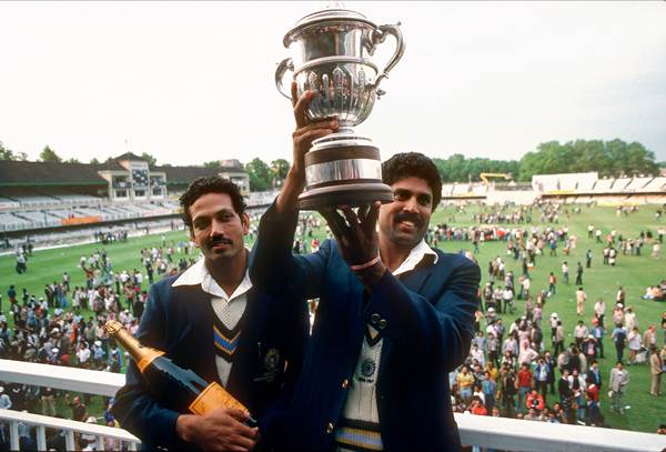 Kapil Dev lifts the World Cup trophy while Mohinder Amarnath poses with the champagne, the MoM award.