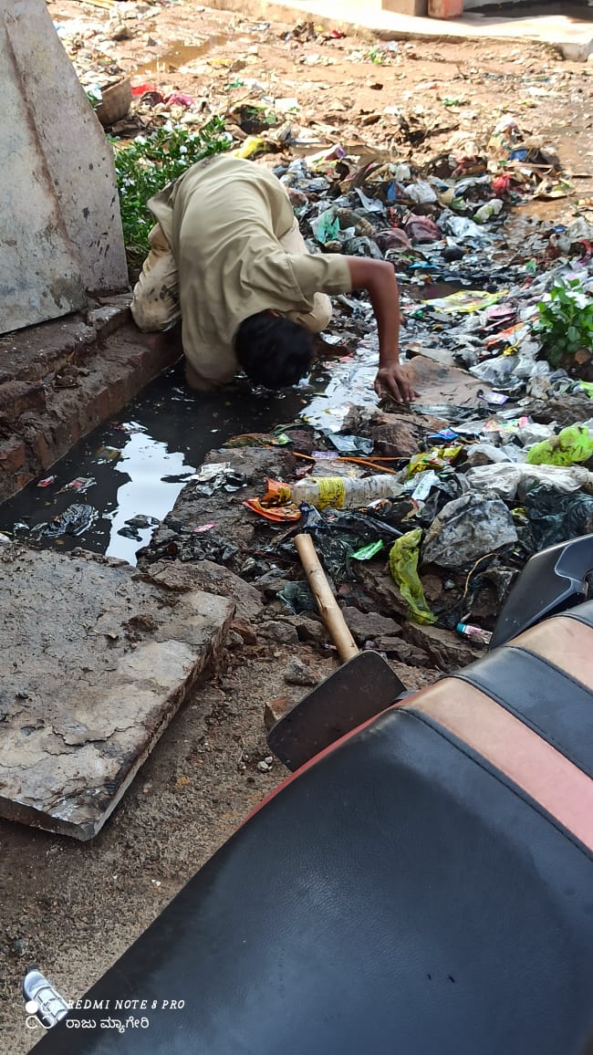 civil worker cleans cleans drainage in bare hands