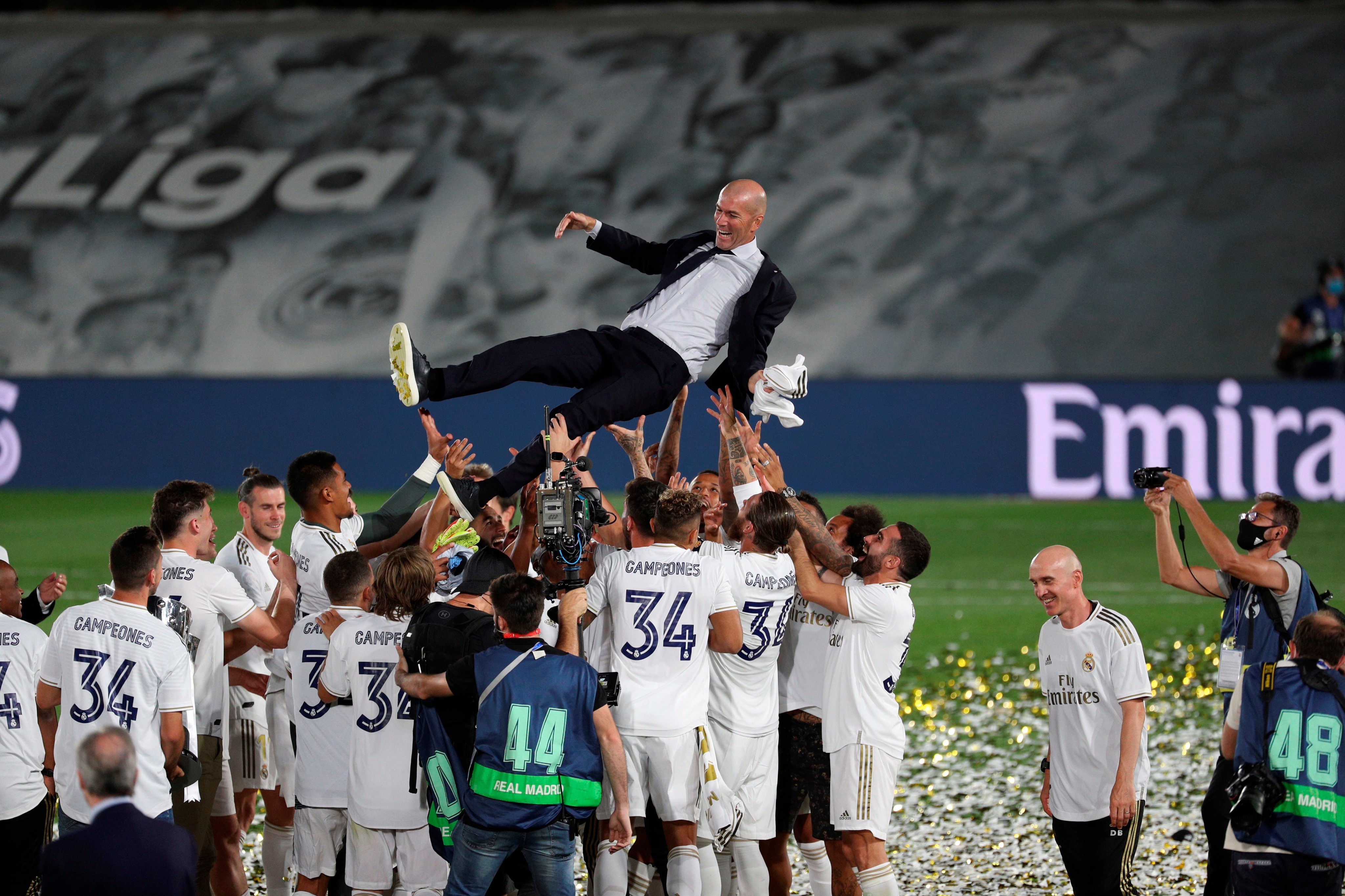 Real Madrid players raise coach Zinedine Zidane in the air.