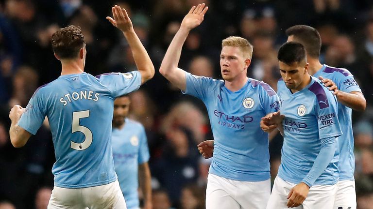 Manchester City players celebrate after scoring a goal.