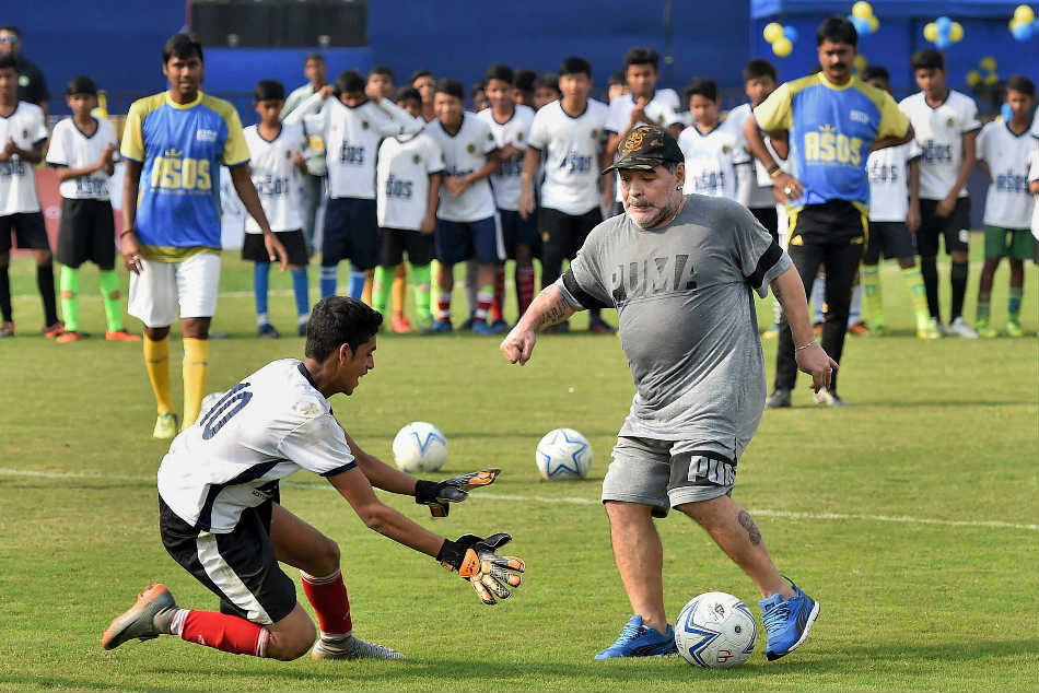 Maradona attempting to dodge a player during an exhibition match in Kolkata.