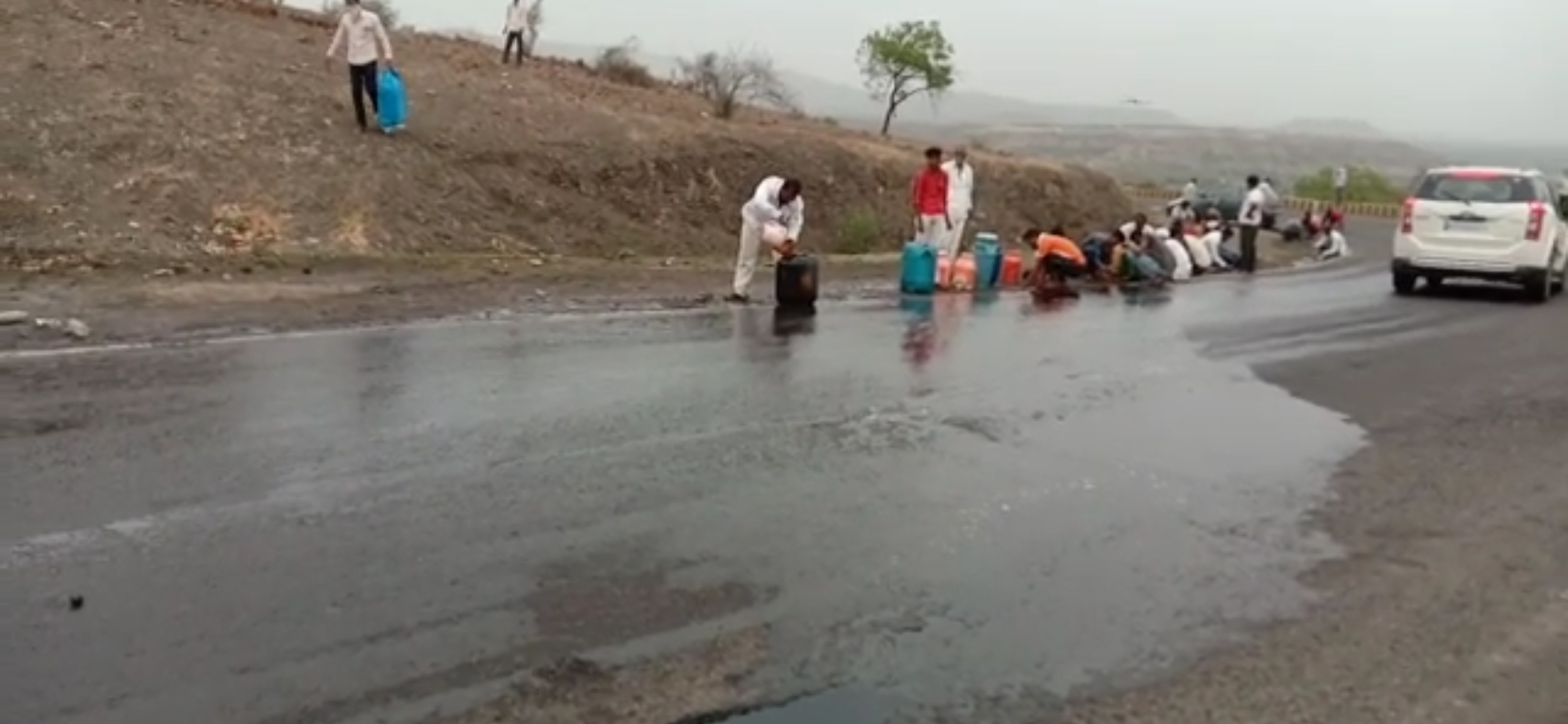 people collect  disel from accident tanker