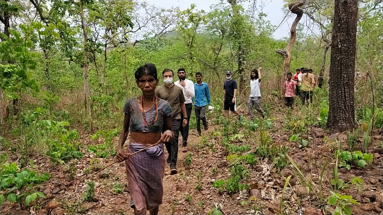 वाडीत जाण्याचा मार्ग दाखवताना आदिवासी महिला