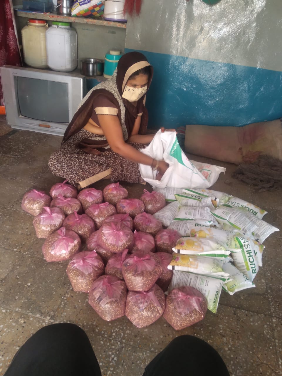 Women members of self-help group distributing ration to poor in Agar Malwa