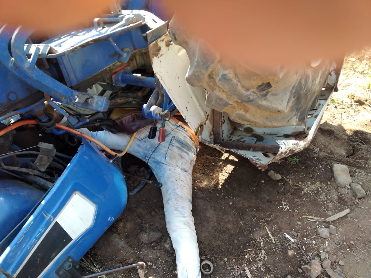 A young man under a tractor