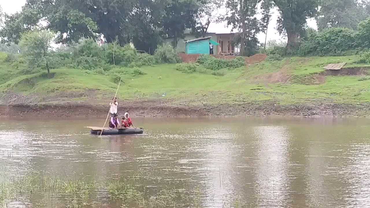 People crossing the river with the help of a boat made of tube and bamboo