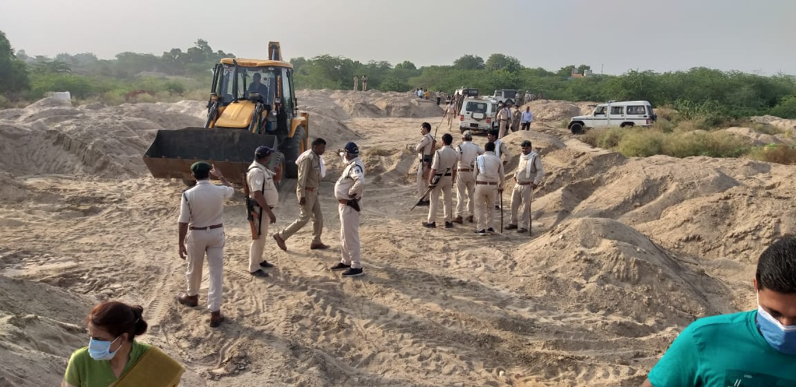 Officials dumping sand with JCB machine