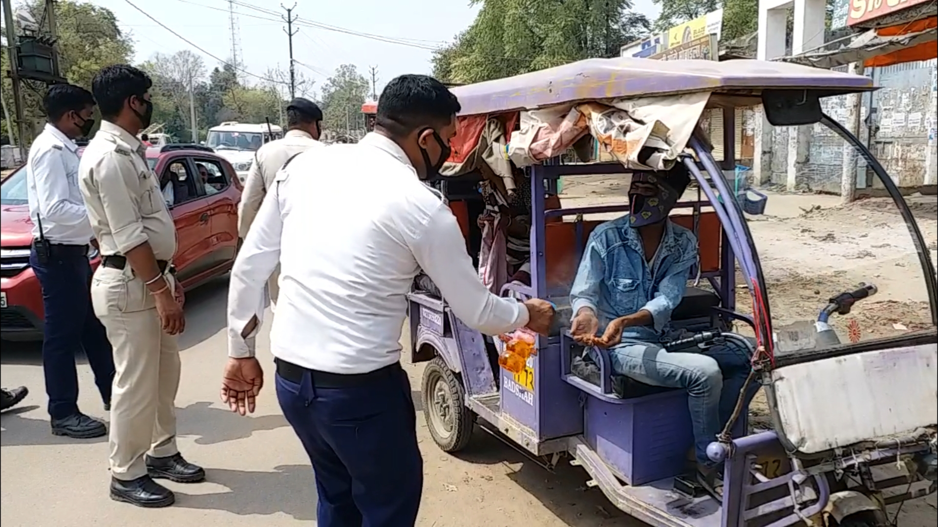 Police giving sanitizer in hand of auto driver