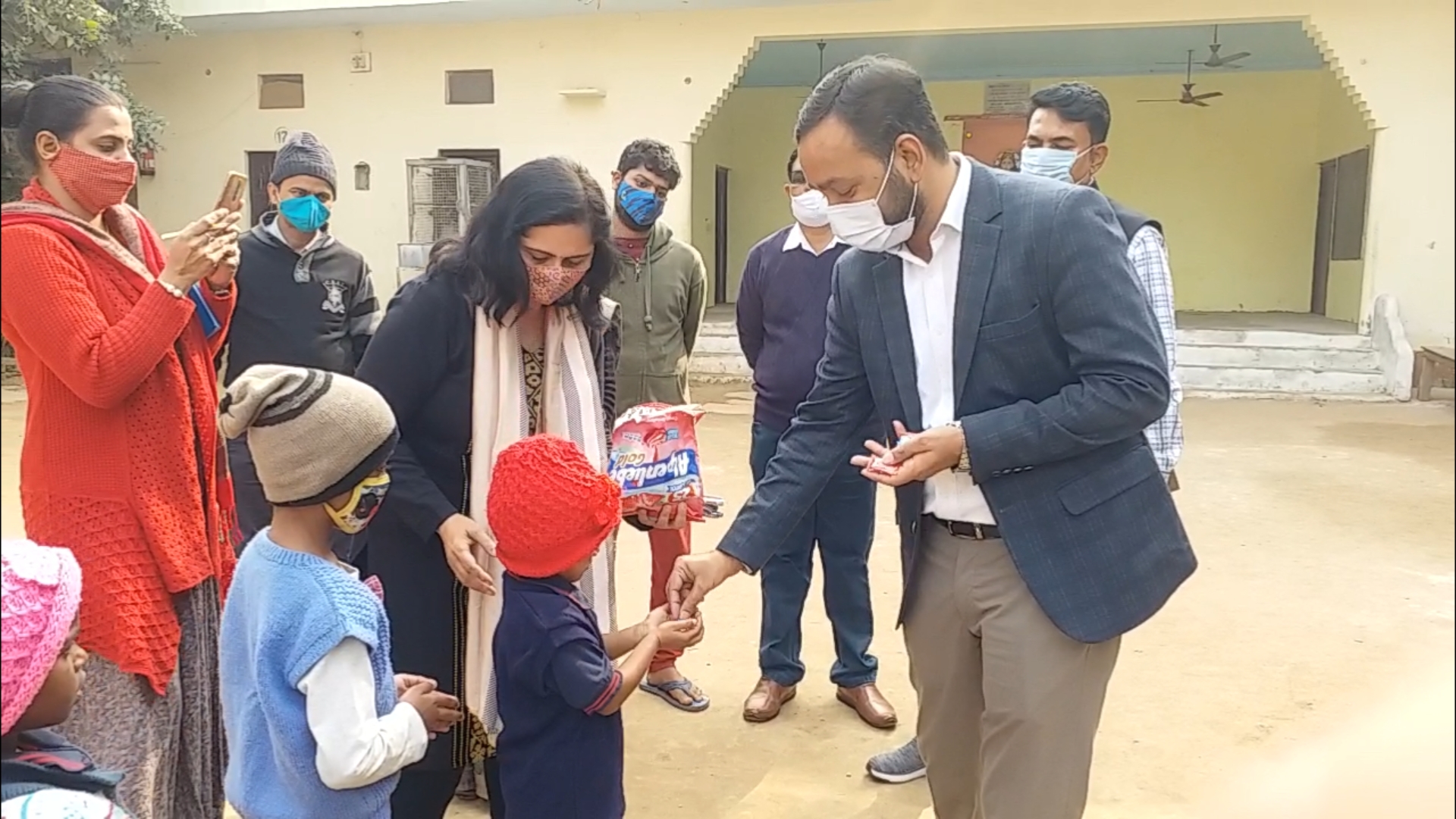 Collectors distributing chocolates to children