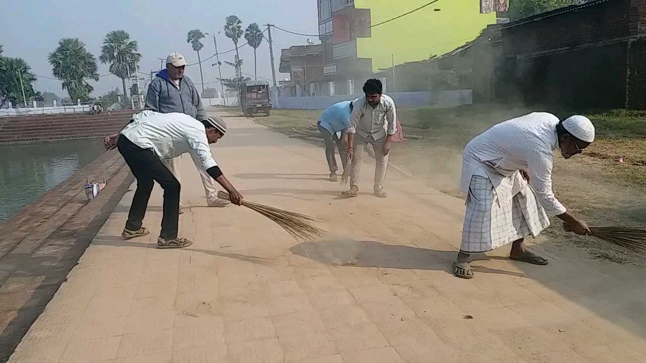 घाट की सफाई करते लोग