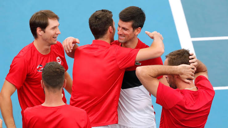 Novak Djokovic celebrates with his teammates.