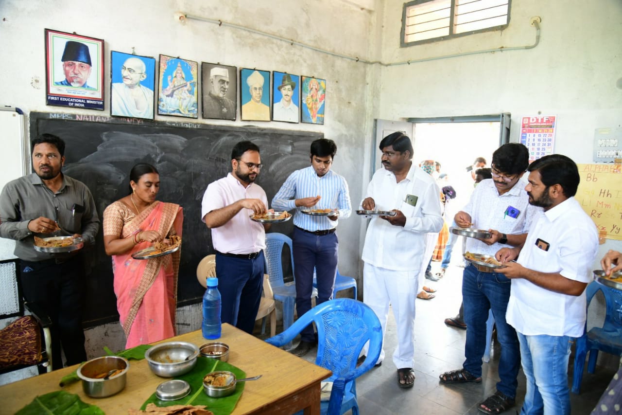 గ్రామస్థులతో కలిసి జొన్నరెట్టె తింటున్న కలెక్టర్