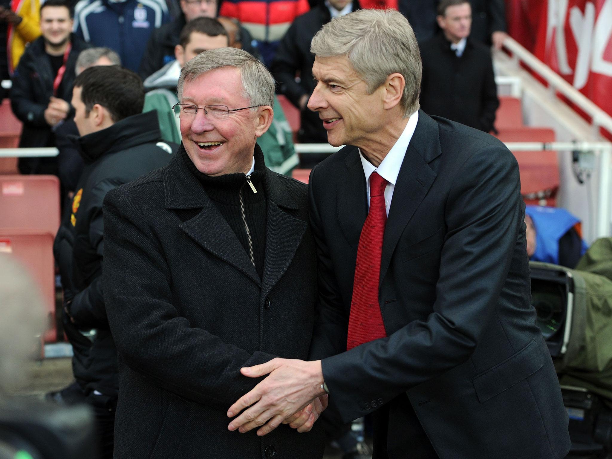 Former Manchester United coach Alex Ferguson and Arsenal manager  Arsene Wenger share a light moment during their managerial days at EPL.