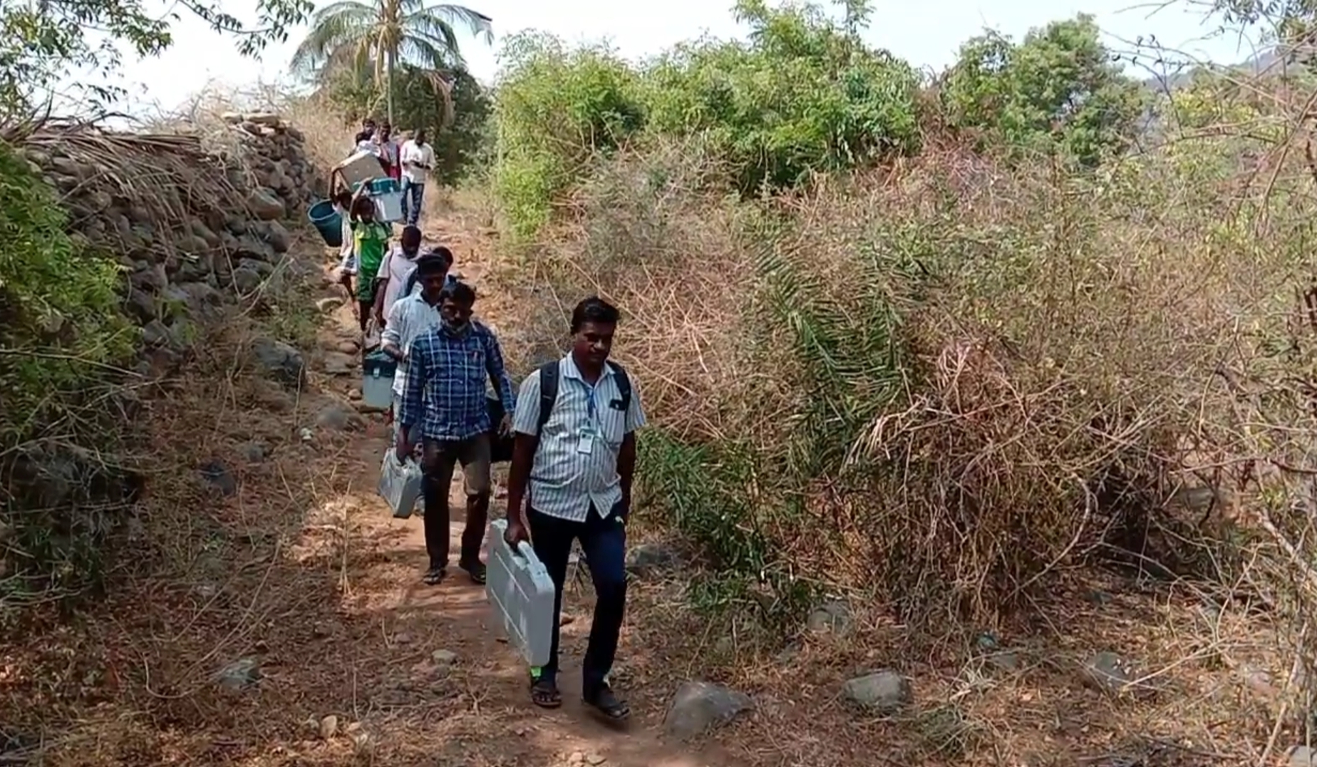 Officers carrying voting machines on their heads in Rasipuram hill villages