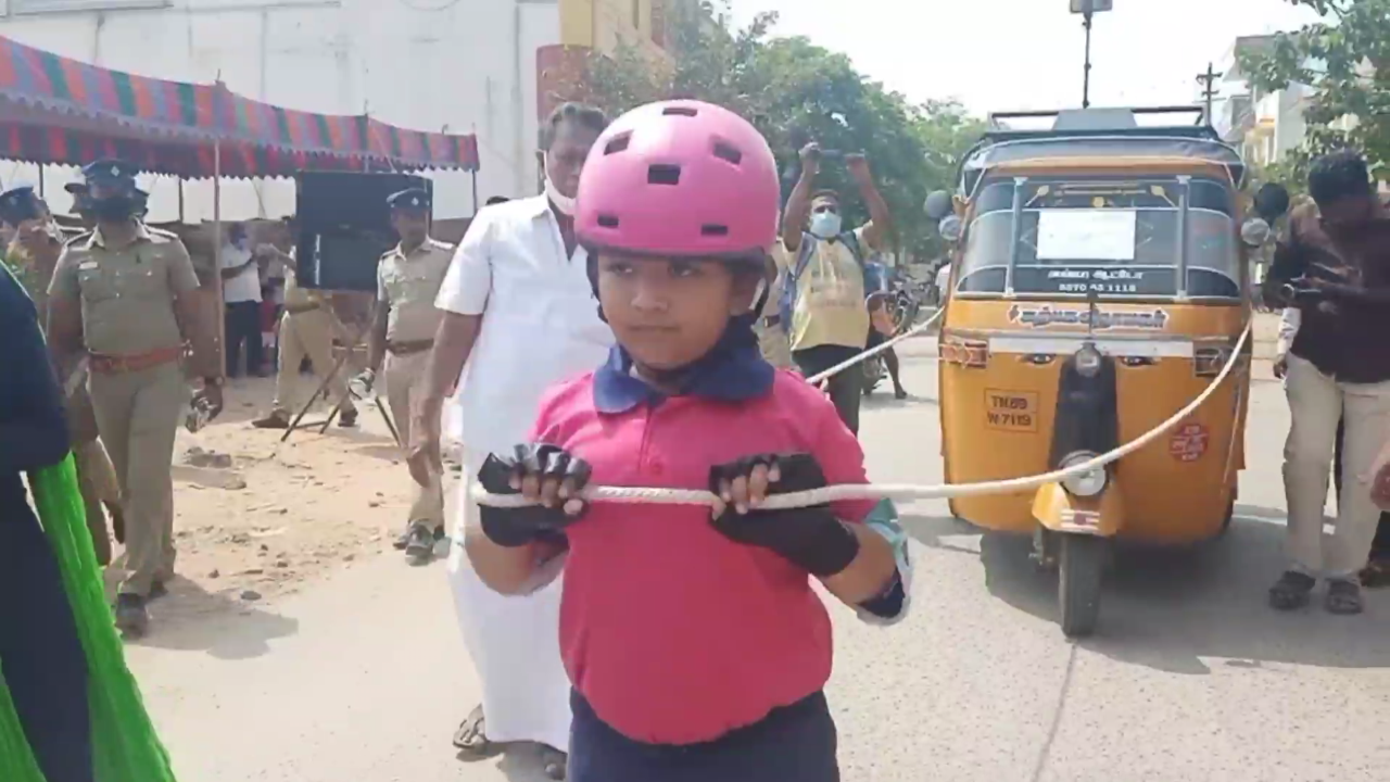 Six year old girl pulls auto by wearing skate roller urging 100 percent voting