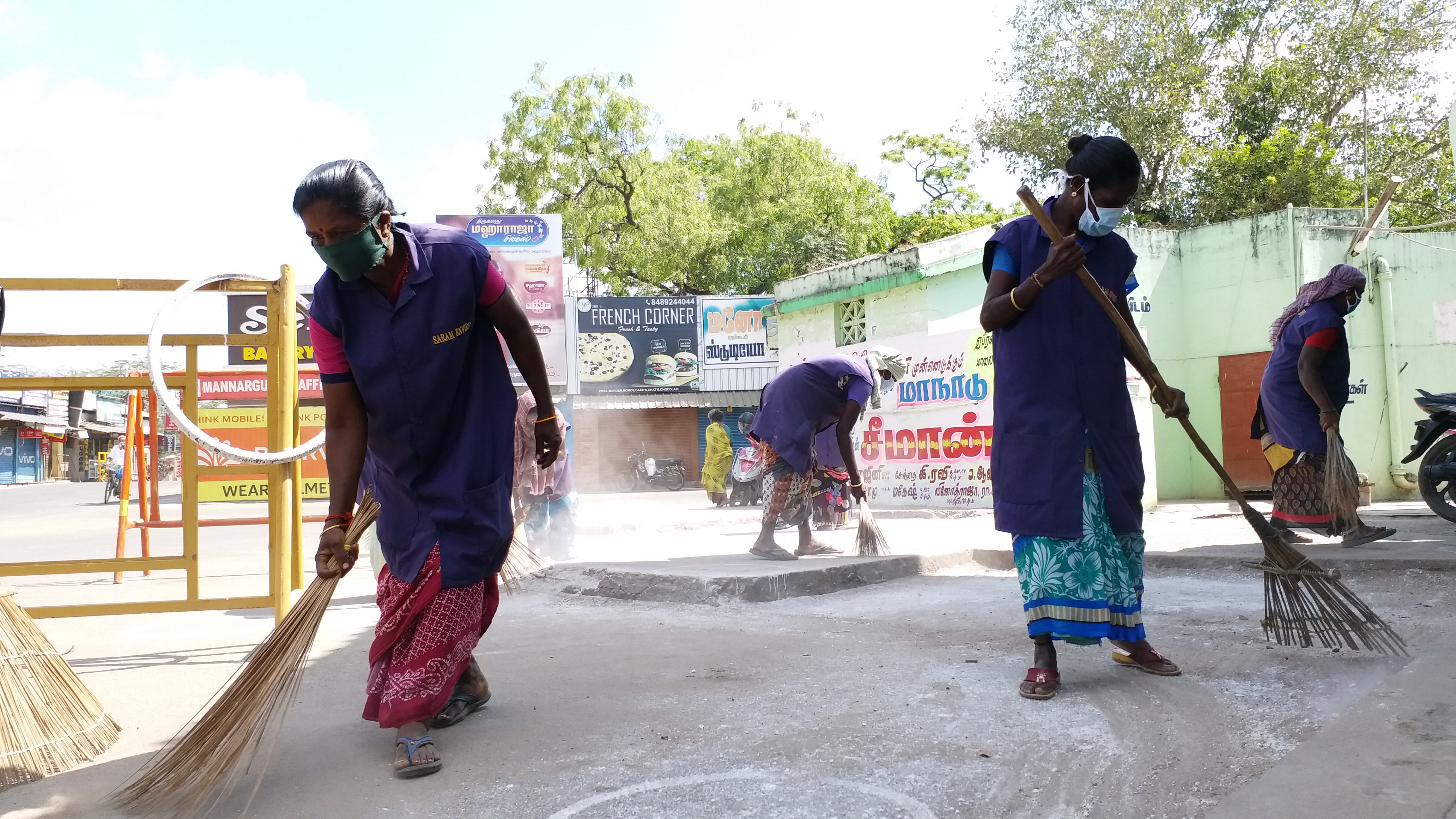 சாலையை சுத்தம் செய்யும் தூய்மை பணியாளர்கள்