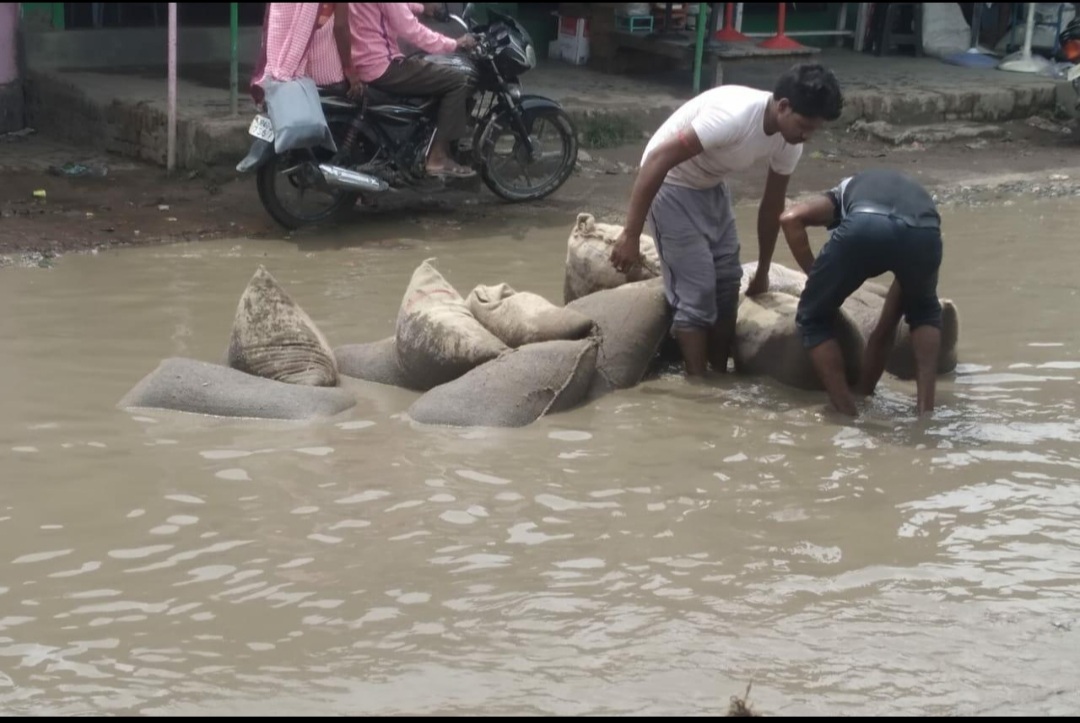 ट्रैक्टर-ट्राली से पानी में गिरीं राशन की बोरियां .